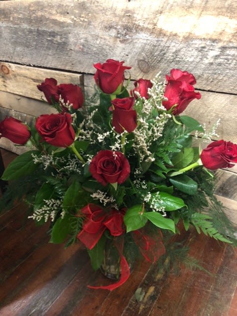 Bouquet of red roses with white filler in a glass vase