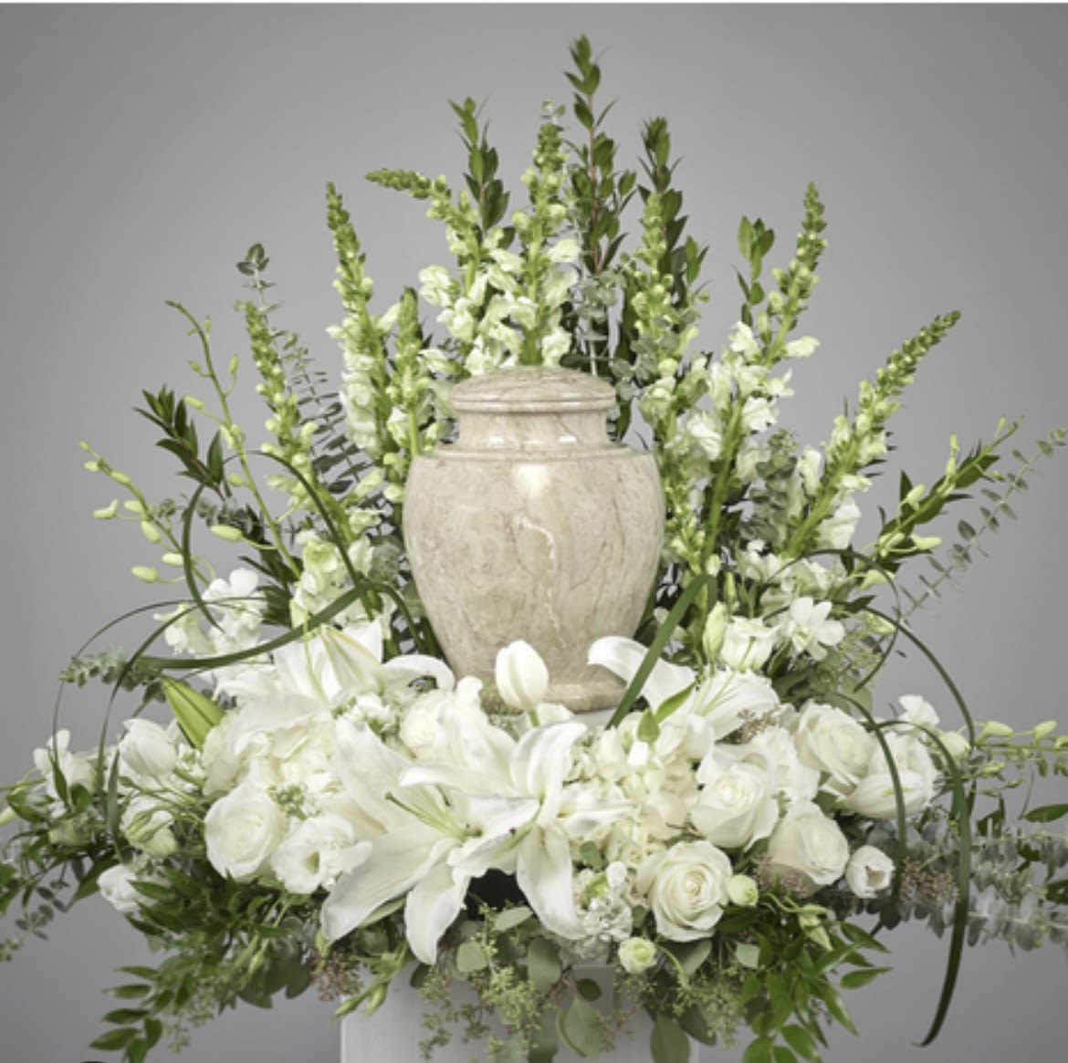From the Heavens  - This arrangement has snapdragons, hydrangeas, orchids, Lillie’s, tulips, roses and beautiful greenery. The image shown above is the premium size only orchids are included in the premium. Urn not included. 