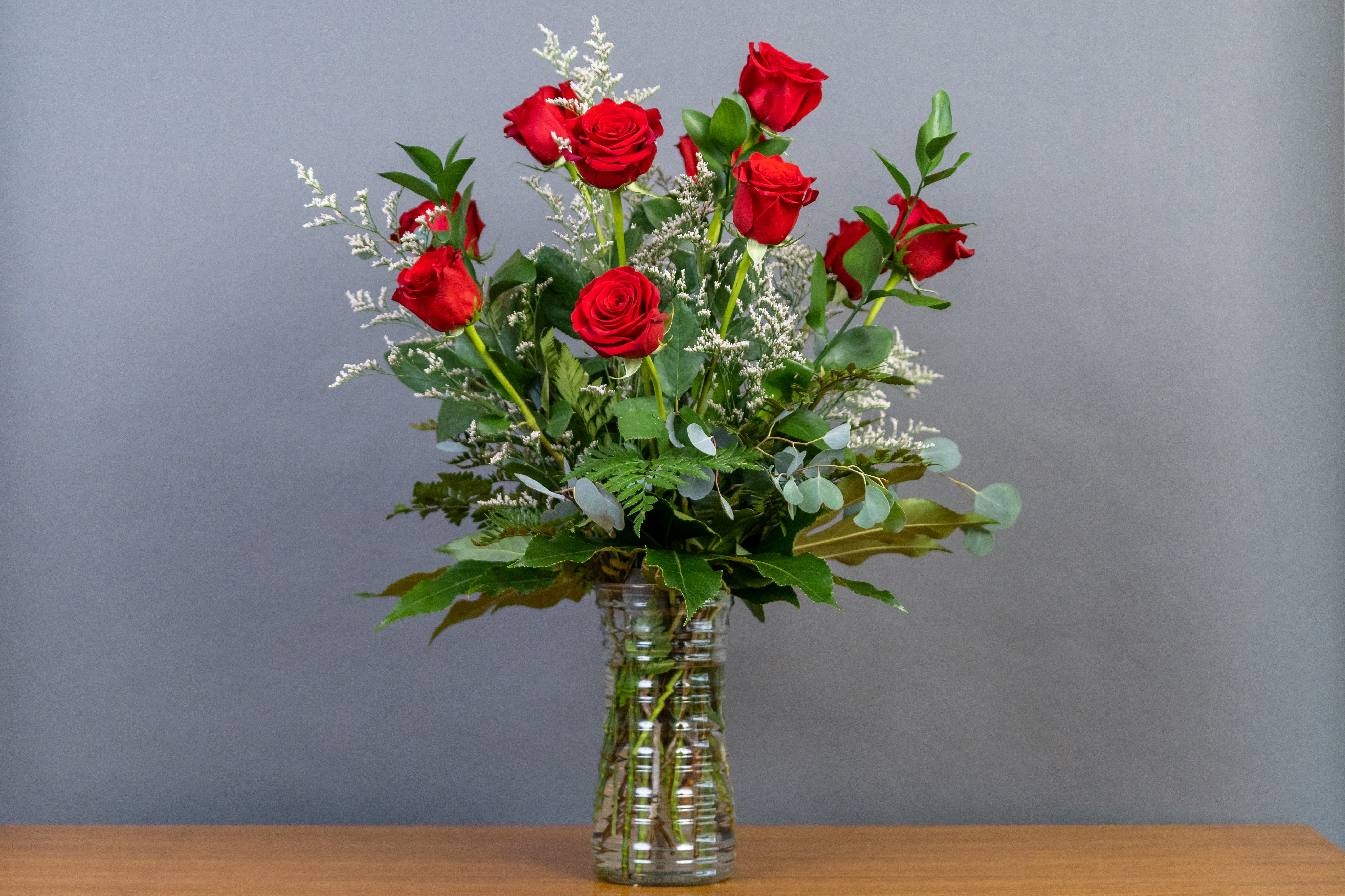 Red roses arranged in a clear glass vase
