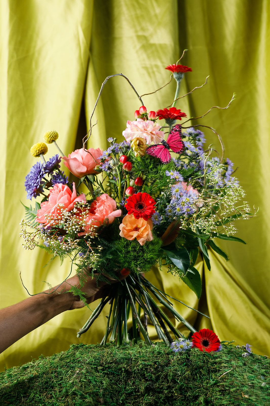 Ladies of the Garden - Ms. Earthworm  - The Foundation Mother  Grounded and quietly beautiful, Miss Earthworm is a study in texture, depth, and natural form.  A mix of seasonal blooms and textural elements creates an organic silhouette—funky, full, and effortlessly beautiful, just like Mom.  It’s less about show and more about substance, with every stem carrying meaning, with the curly willow representing Ms. Earthworm.   Hand-tied and ready to display, this piece honors the mother whose work isn’t always seen—but is always felt. The one who builds the foundation that everything else grows from.  To keep your blooms fresh, trim stems and refresh water every few days.  Please note that this is an exclusive curated bouquet for May 8-10. 