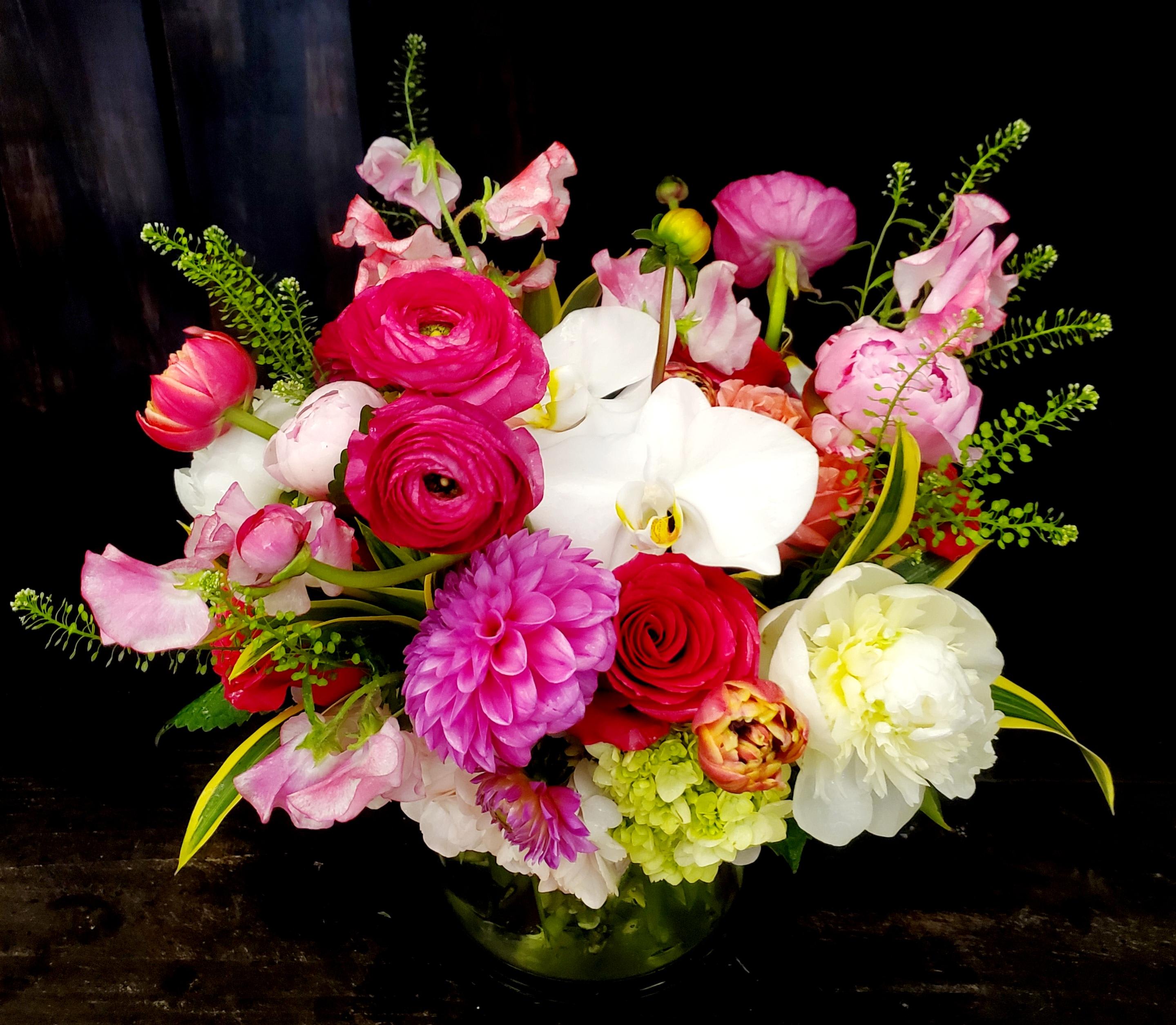 Mixed pink and white floral arrangement in a glass vase