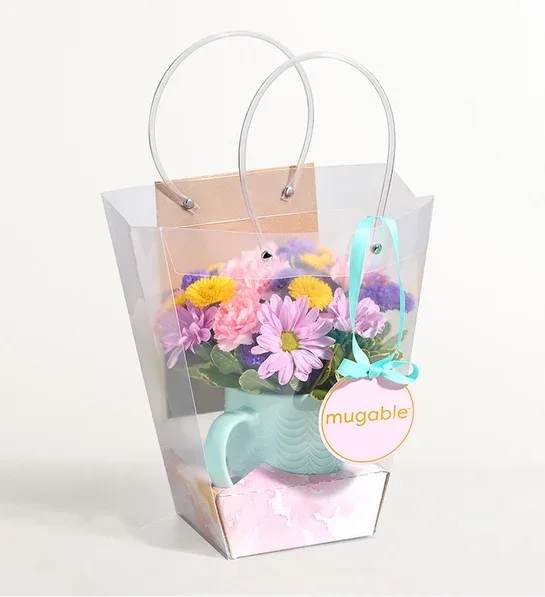 One Of A Kind MUGABLE - All-around arrangement of fresh blooms, selected and arranged in a reusable mug by our expert florists Measures approximately 8.5” x 5”W Arrives in a transparent bag with a holder for a personalized Card Isle greeting card (available for an additional cha