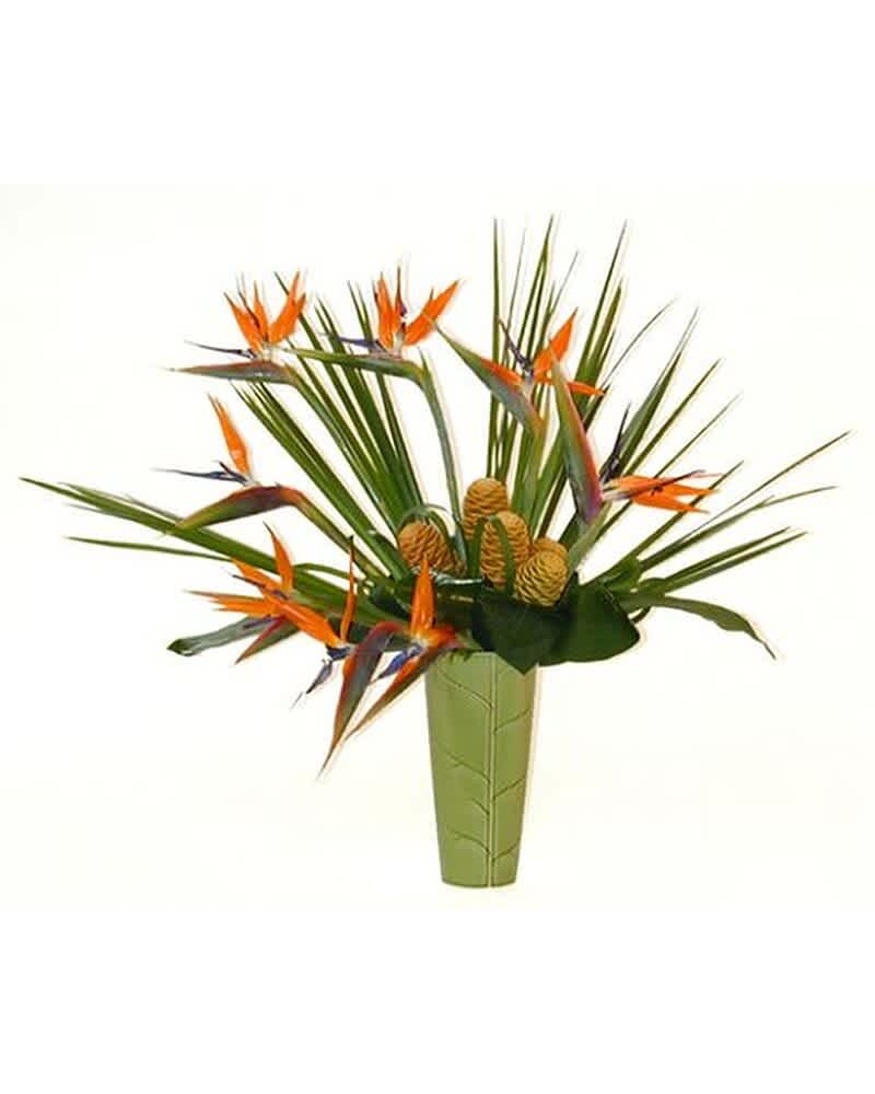 Tall green vase with orange tropical flowers and palm fronds in a fan-like arrangement
