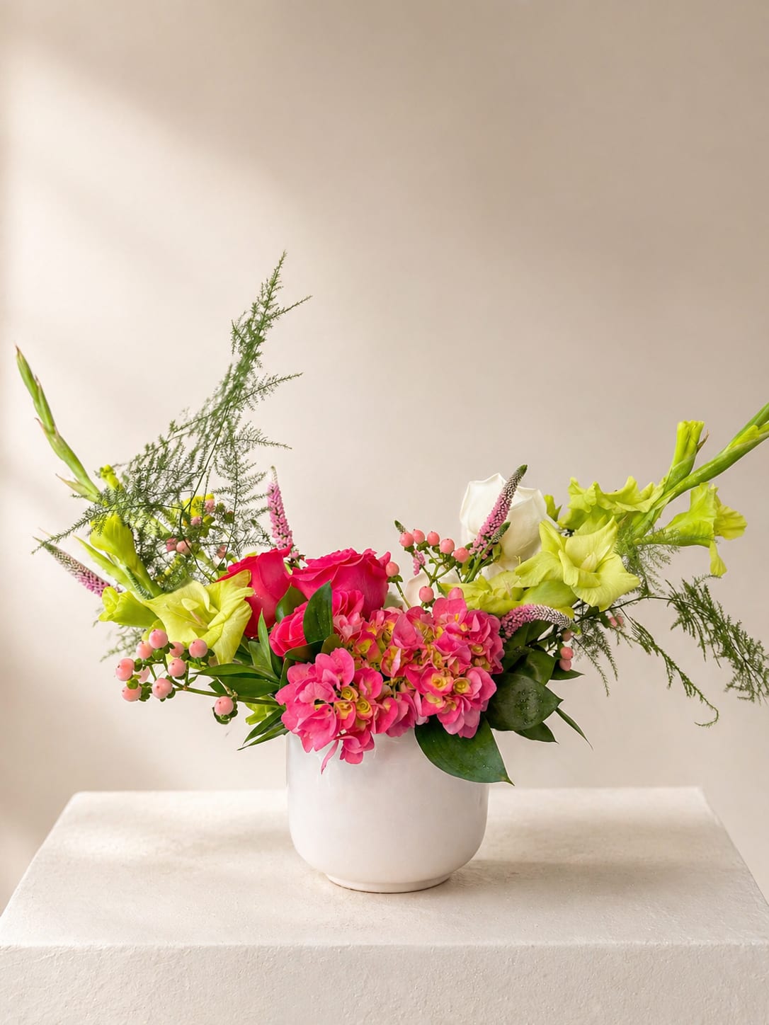 Her Radiance - A joyful, garden-style arrangement in vibrant pinks, soft white, and fresh spring green. Designed with airy movement and a sculptural silhouette, this piece feels bright, celebratory, and full of life.