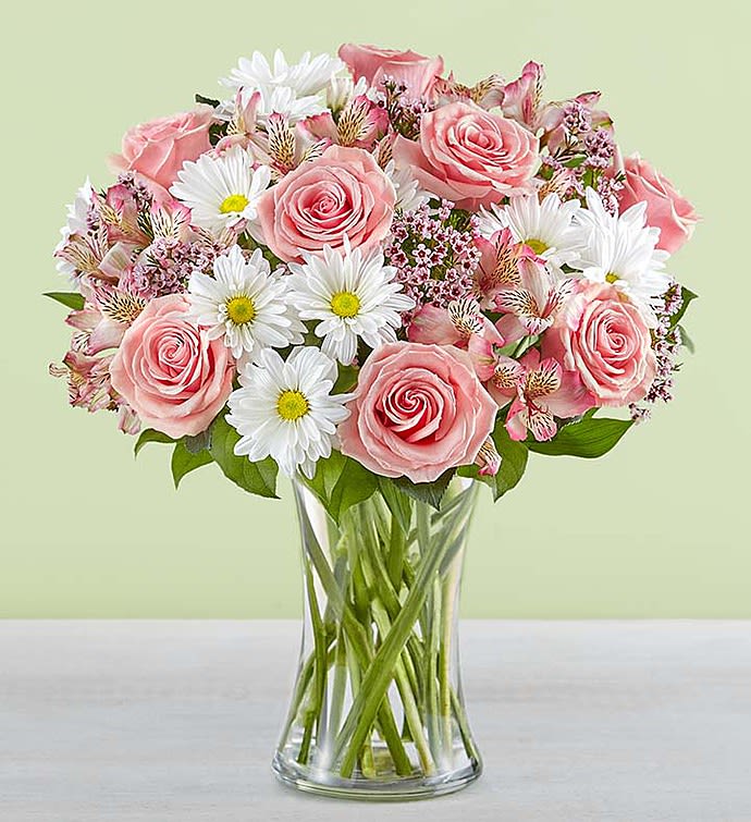 Pink roses and white daisies in a clear glass vase