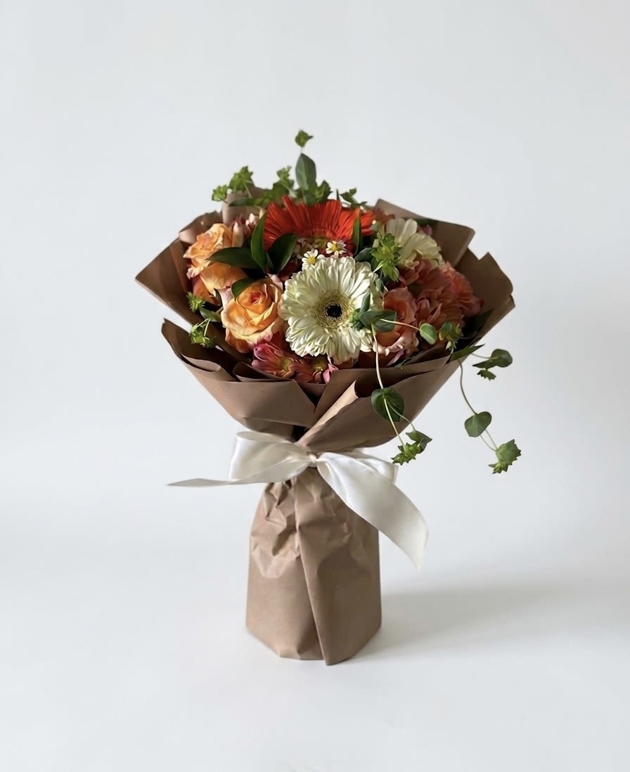 Sunset Artisan Hand-Tied Bouquet - Sunset Artisan Hand-Tied Bouquet Elevate your gifting with our Sunset Artisan Hand-Tied Bouquet. Featuring vibrant orange roses and white gerbera daisies, this premium floral design is expertly spiraled and wrapped in eco-friendly kraft paper. Perfect as a luxury flower gift or a chic home accent, it offers a natural, garden-fresh look delivered straight from our boutique floral studio.