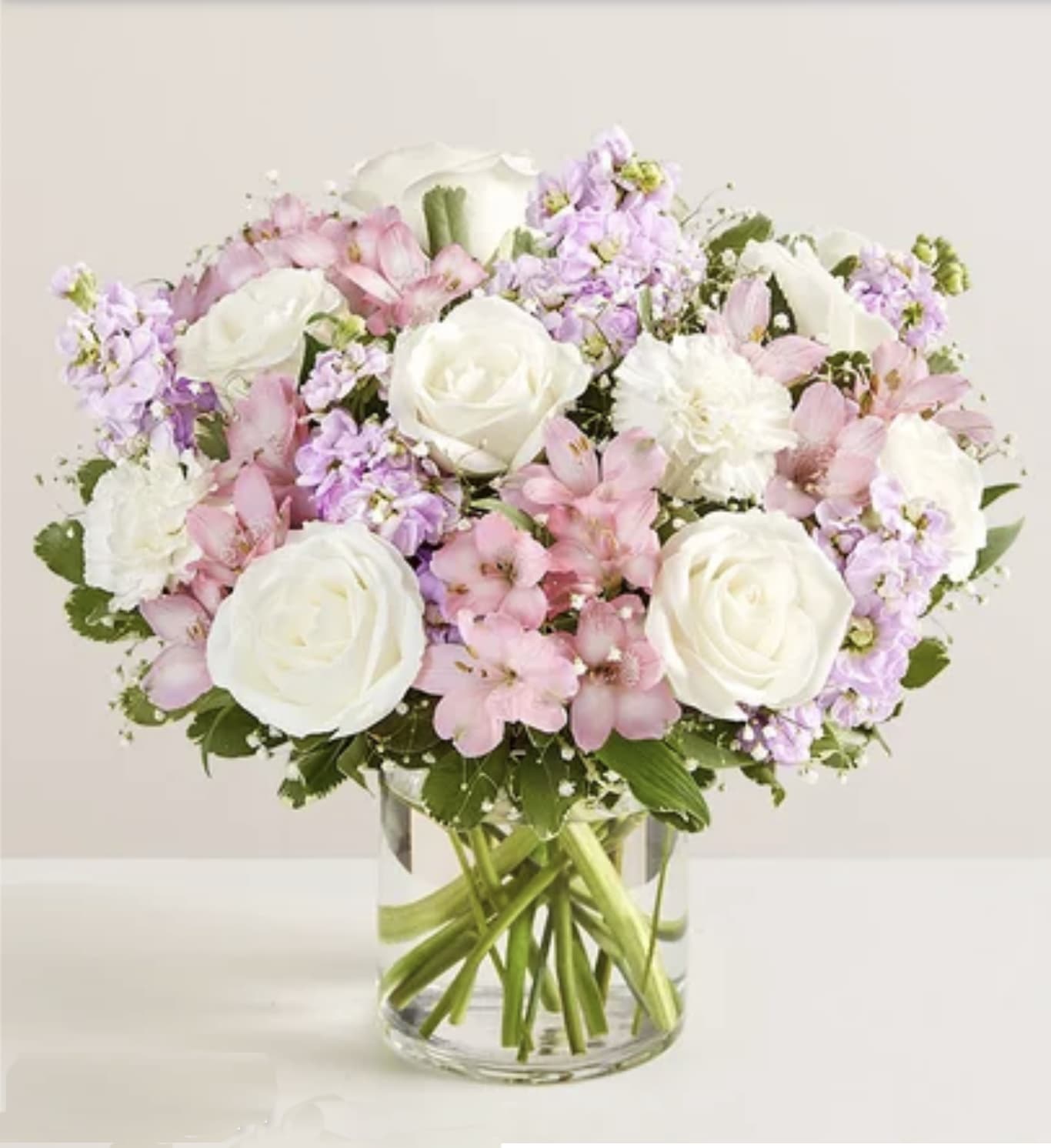 Bouquet of white roses and pink flowers in a clear glass vase