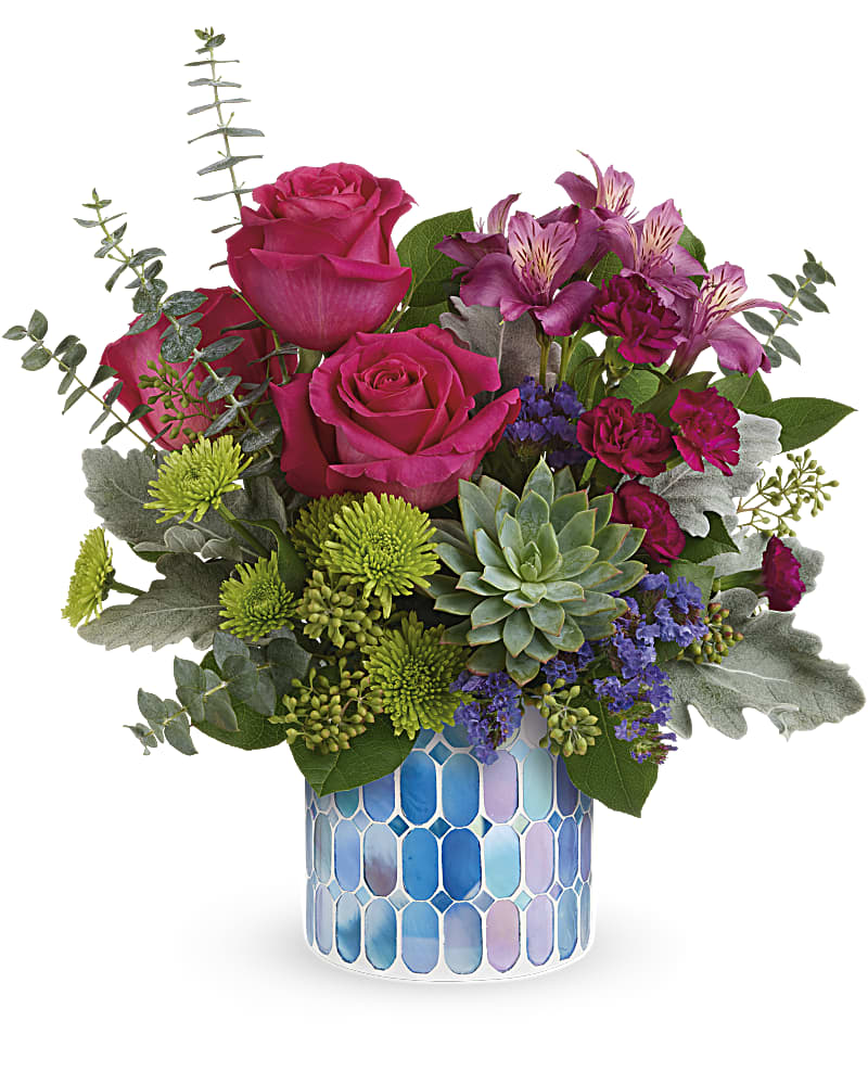 Pink roses and mixed flowers in a blue mosaic vase