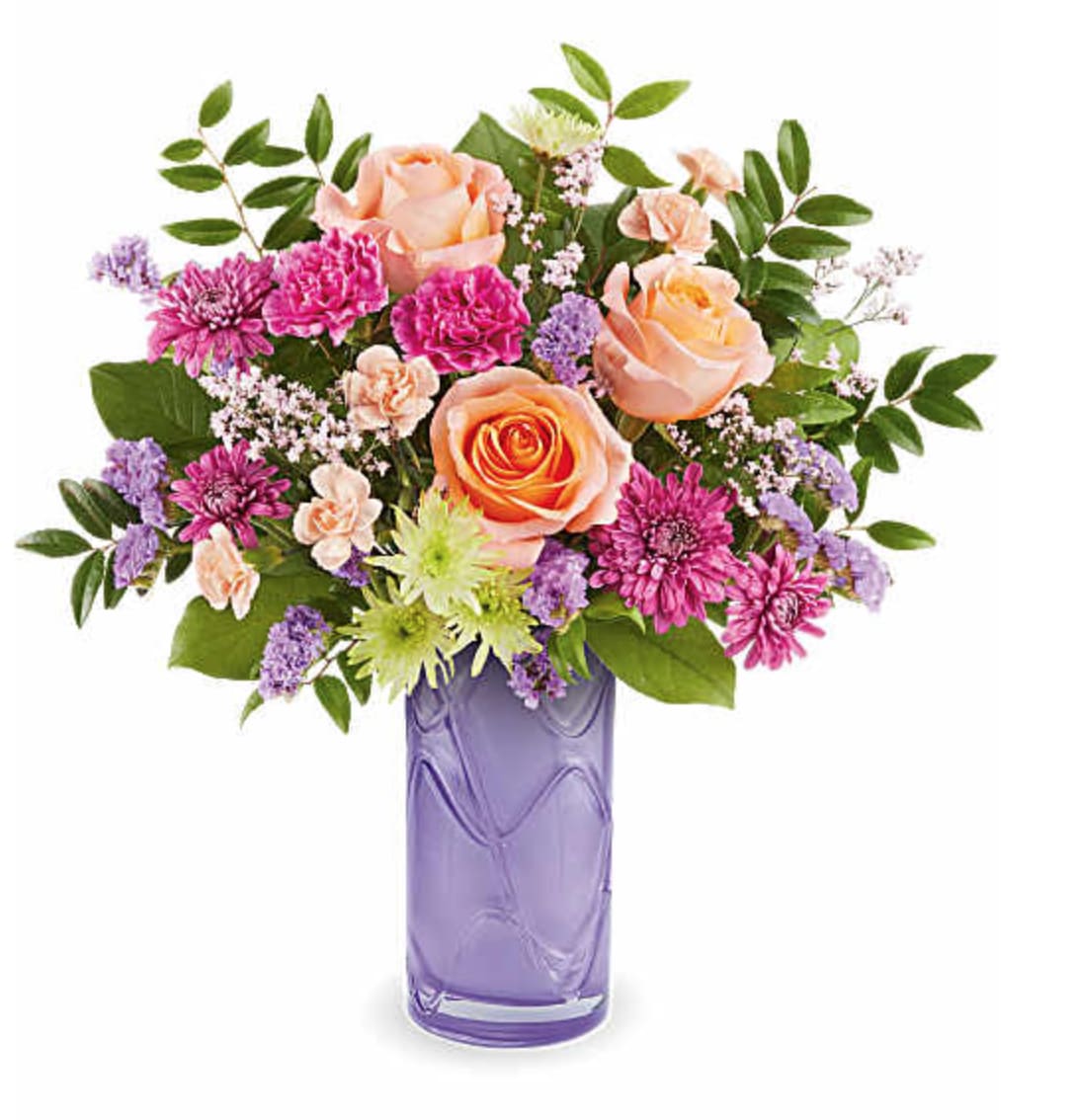 Pretty Daydream Bouquet - Celebrate her sweetest moments with the Pretty Daydream Bouquet, a dreamy mix of soft, vibrant blooms beautifully arranged in a Pretty Daydream Vase-a charming keepsake she'll enjoy long after Mother's Day. Our Pretty Daydream Bouquet features peach roses, fuchsia carnations, miniature peach carnations, green and purple cushion spray chrysanthemums, purple sinuata statice, and pink limonium, accented with huckleberry and salal, delivered in our Pretty Daydream Vase. Orientation: All-Around