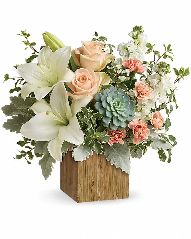 Bouquet of white lilies, peach roses, and carnations in a wooden cube vase