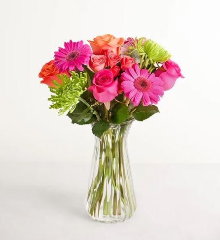 Vibrant Blooms Flower  -  Pet Friendly? No This arrangement contains Spider Mums (Chrysanthemums), which are toxic to dogs and cats if ingested. Keep this vase on a high mantel or shelf out of reach of household pets.    Human Allergy Note Contains Gerbera Daisies and Spider Mums, which produce visible pollen and may trigger sensitivities in hay fever sufferers. Keep the arrangement in a well-ventilated area away from the bedside.   Care &amp; Longevity To keep your blooms vibrant, check the water level daily and top off with fresh, cool water. Every few days, carefully change the water entirely and trim the stems at a 45-degree angle to improve hydration. Keep the vase away from direct sunlight, heating vents, and ripening fruit to extend the life of the roses.   Best Occasions &amp; Situations  Milestone Birthdays  Congratulations / Promotions  Get Well Wishes ️ Just Because / Cheer Up  Office Desk Brightener  Housewarming Gift  ⭐ Why Customers Love It High-Contrast Palette: The neon-bright colors provide an instant mood boost. Textural Variety: Features a beautiful mix of soft rose petals and “spiky” spider mums. Gift-Ready: Arrives in a reusable fluted glass vase that fits any decor. Long Lasting: Mums and Gerberas are known for their excellent vase life.