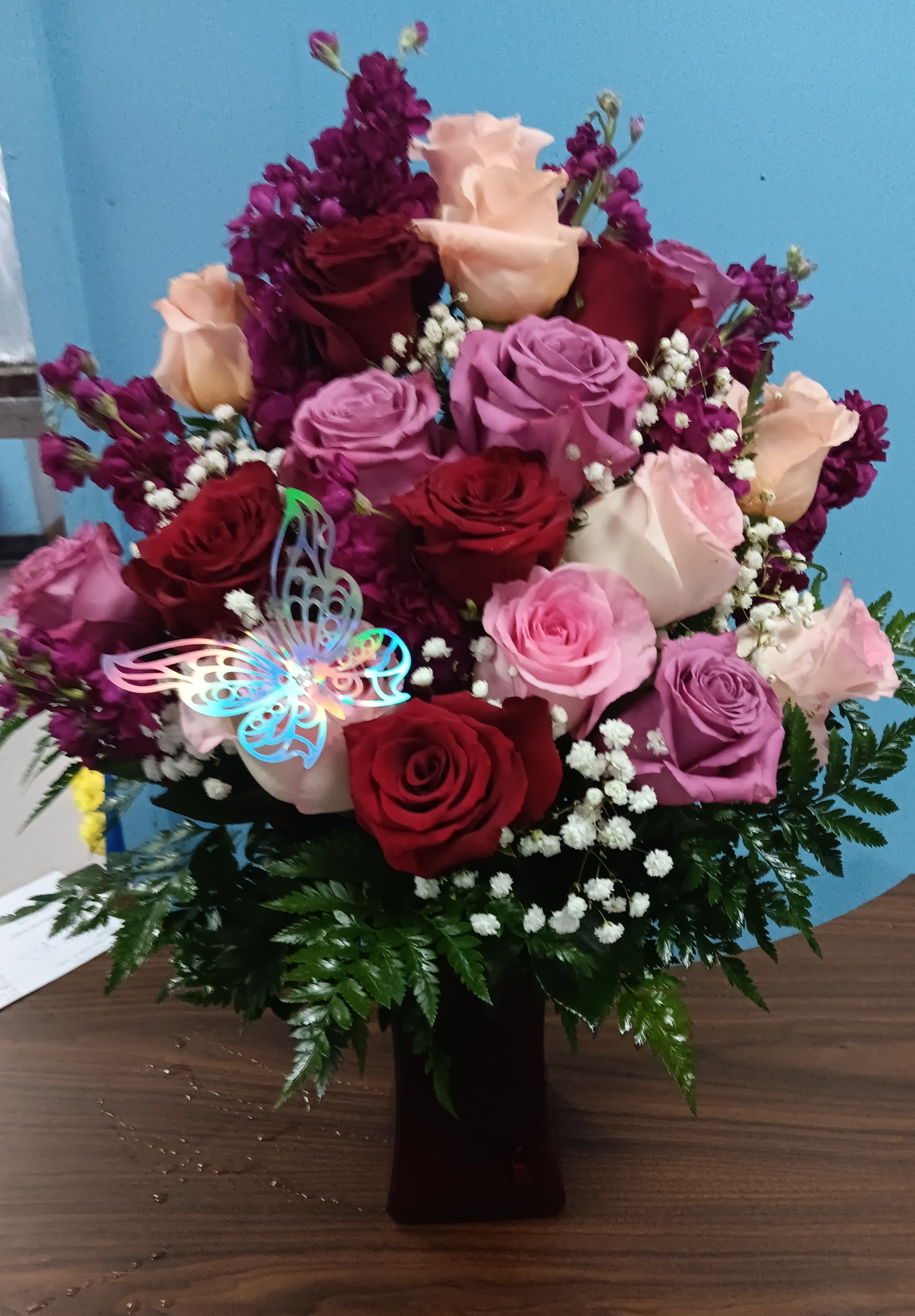  Pure Romance - Utterly romantic and blossoming with your love through every blushing bloom, this gorgeous rose bouquet is out to convey your heart's every wish. Hot pink, red, and lavender roses mingle with fragrant fuchsia gilly flowers, beautifully accented with lush greens while seated in a vibrant pink glass vase. The perfect anniversary, "I love you," or Valentine's Day gift! GOOD bouquet includes 9 stems. Approx. 14"H x 11"W. BETTER bouquet includes 12 stems. Approx. 15"H x 11"W. BEST bouquet includes 17 stems. Approx. 16"H x 12"W. EXQUISITE bouquet includes 24 stems. Approx. 17"H x 14"W. 