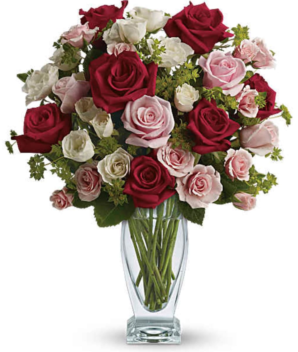 Cupid's Creation with Red Roses - "Love her tender" with silky red, pink and white roses artistically arranged in a chic clear glass couture vase. Oh, the hugs, the kisses you'll get for choosing such a breathtaking bouquet. The romantic bouquet includes red roses, pink roses, white spray roses and light pink spray roses accented with assorted greenery. Delivered in a clear glass couture vase. Orientation: All-Around  SUBSTITUTION POLICY – Always deliver the freshest flowers! Please note the bouquet pictured reflects our original design.  If the exact flowers or container in this arrangement are not available, our local florists will create a beautiful bouquet with the freshest available flowers.