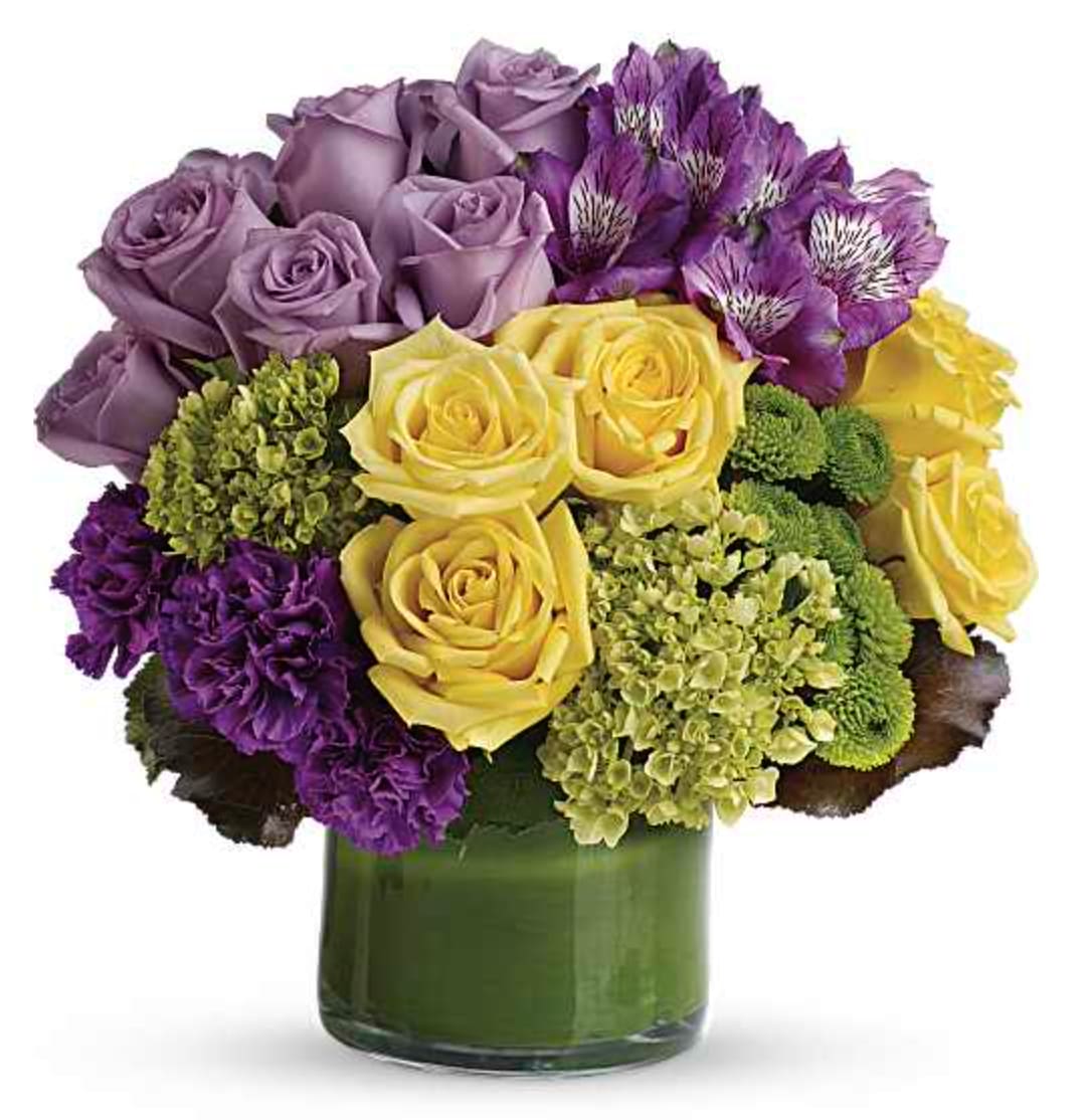 Simply Splendid - A simply splendid way to surprise someone special! Hand-delivered in a stylish, leaf-wrapped vase, This sophisticated, sunshiny arrangement of hydrangea and roses is an instant pick-me-up! This chic arrangement includes miniature green hydrangea, lavender and yellow roses, purple alstroemeria, dark purple carnations, green button spray chrysanthemums, galax leaves and a ti leaf. Delivered in a clear glass vase. Orientation: All-Around  SUBSTITUTION POLICY – Always deliver the freshest flowers! Please note the bouquet pictured reflects our original design.  If the exact flowers or container in this arrangement are not available, our local florists will create a beautiful bouquet with the freshest available flowers.