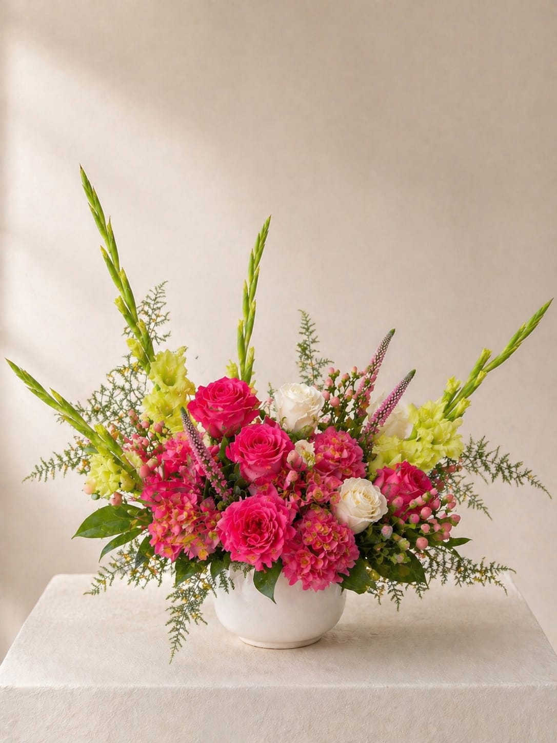 Love in Bloom - Lush, abundant, and unmistakably celebratory, this arrangement is designed in vivid pinks with soft white accents and fresh seasonal texture. Its full, expressive shape captures a feeling of generosity, beauty, and abundance.
