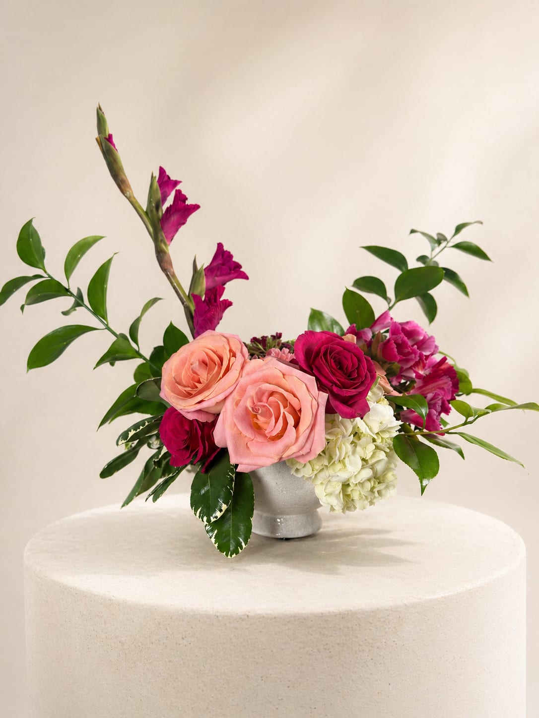 Raspberry Kiss - A modern, feminine arrangement in peach, raspberry, and soft green, designed with sculptural lines and romantic texture. This piece feels playful, expressive, and full of warmth.