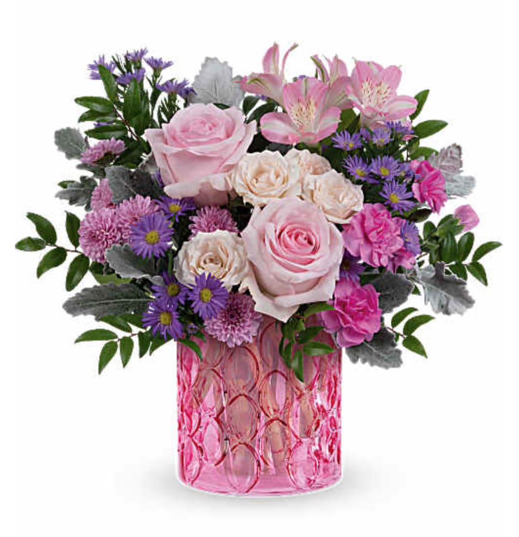 Nouveau Haute Pink Bouquet - Celebrate Mom with our Nouveau Haute Pink Bouquet, a graceful mix of pink and lavender blooms beautifully arranged in our Pink Rhapsody Vase. This thoughtful Mother's Day surprise adds soft color and cheerful charm to her home. Nouveau Haute Pink is a beautiful Mother's Day floral arrangement featuring pink roses, crème spray roses, pink alstroemeria, miniature hot pink carnations, lavender button spray chrysanthemums, and large purple monte cassino asters, accented with dusty miller and huckleberry, delivered in the Pink Rhapsody Vase. Orientation: All-Around  SUBSTITUTION POLICY – Always deliver the freshest flowers! Please note the bouquet pictured reflects our original design.  If the exact flowers or container in this arrangement are not available, our local florists will create a beautiful bouquet with the freshest available flowers.