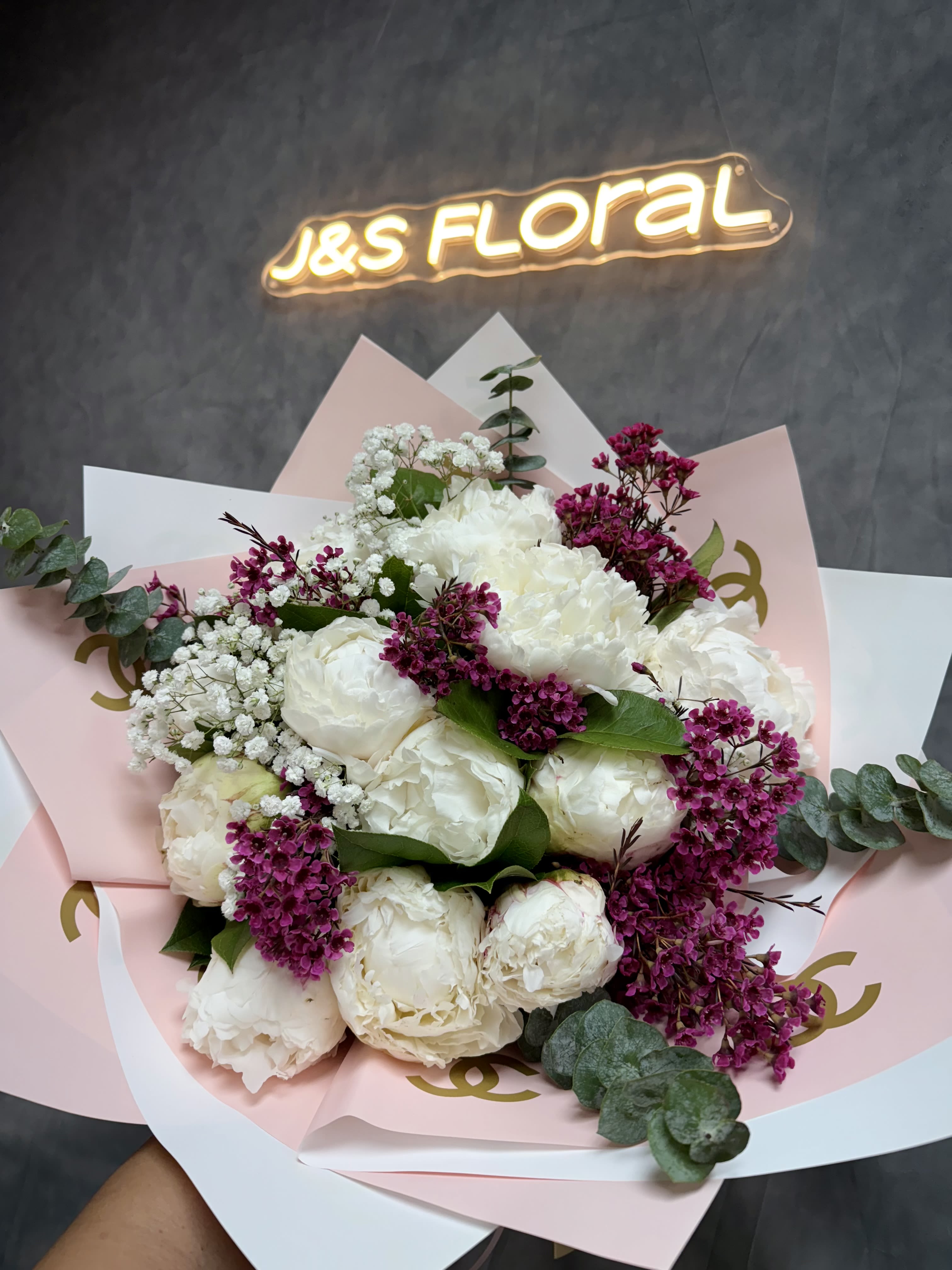 White peony bouquet with magenta filler flowers and pastel wrapping