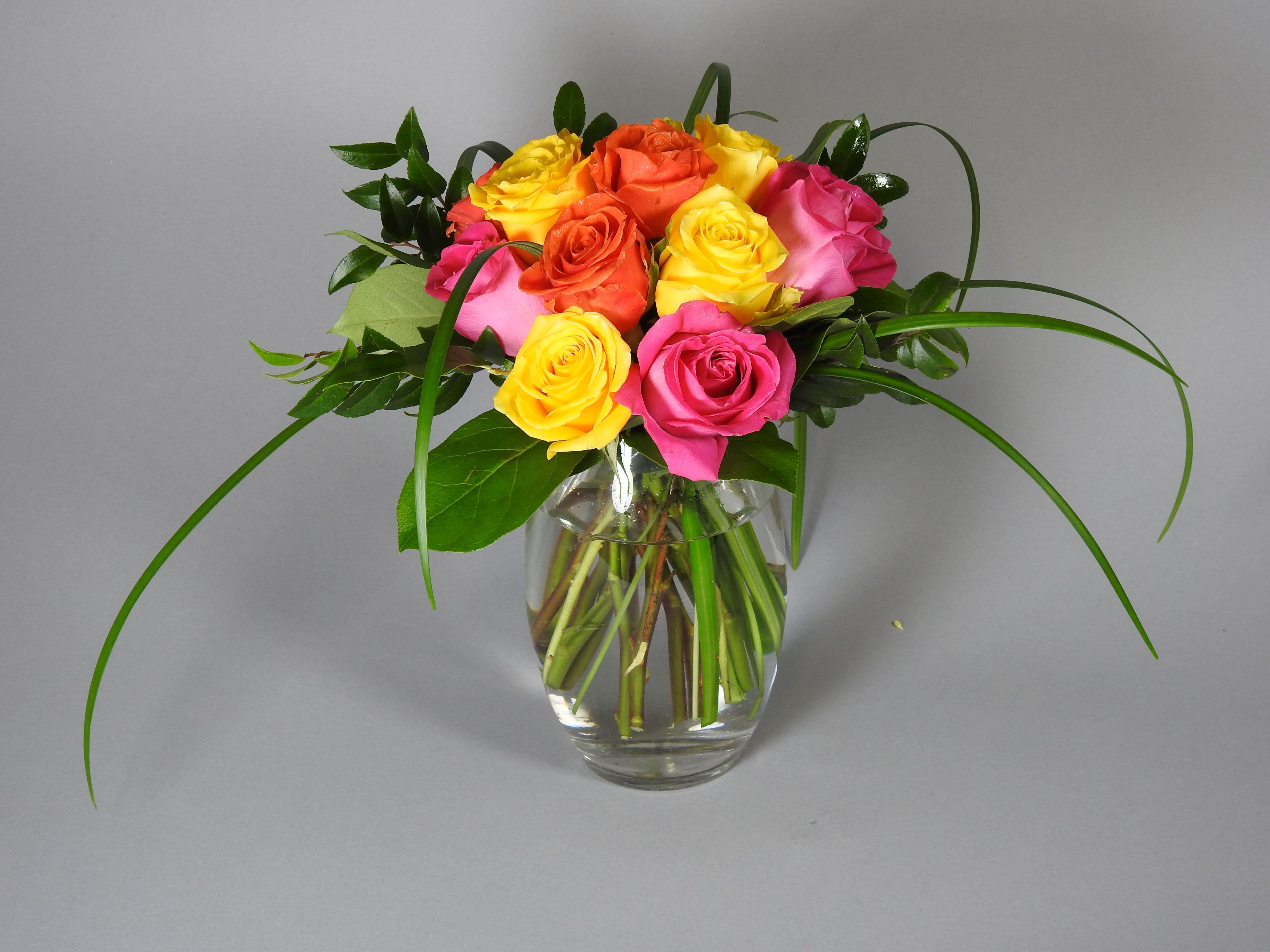 Bouquet of multicolored roses in a clear glass vase