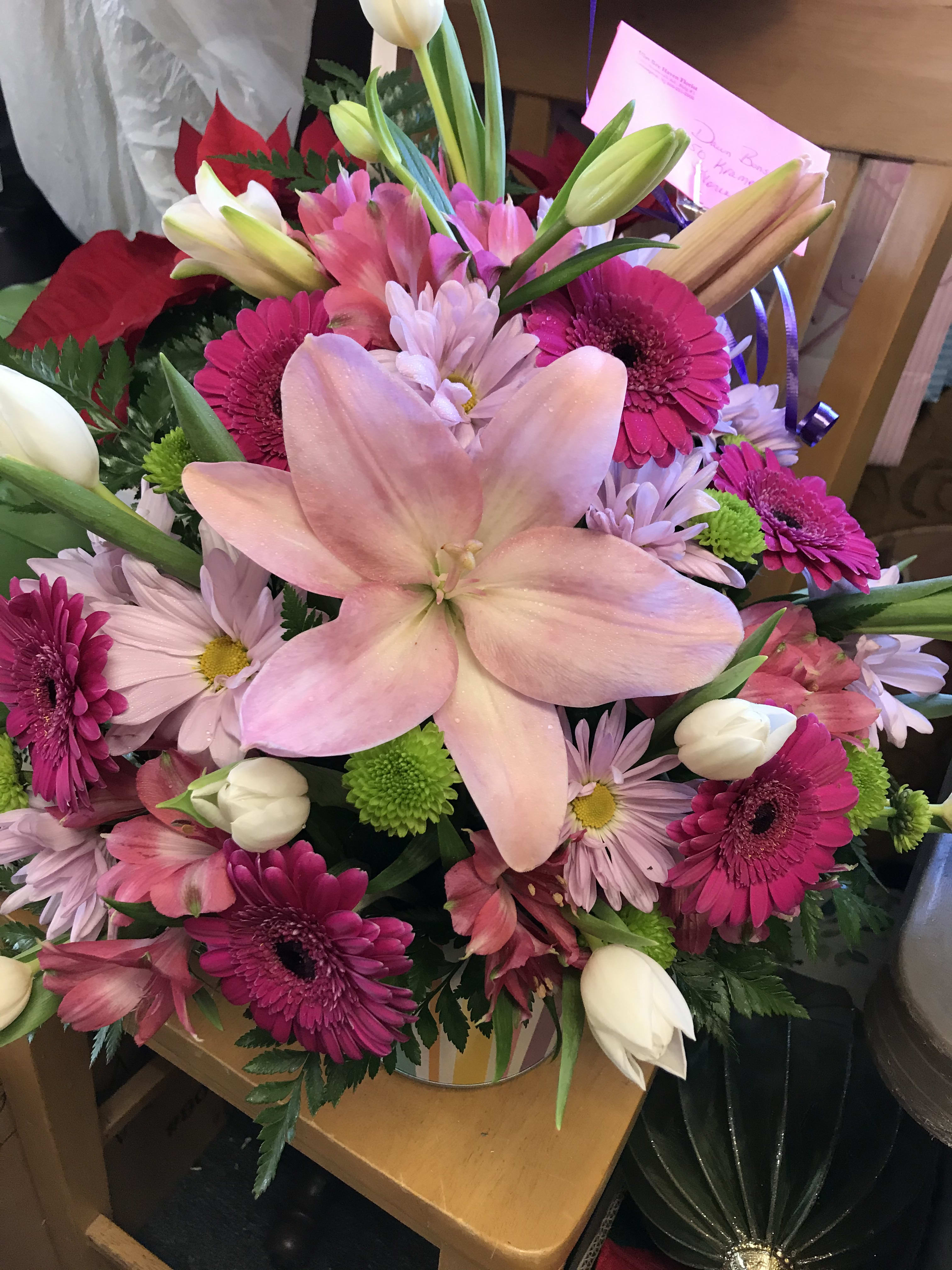 Pink lily bouquet with magenta daisies and white tulips in a vase