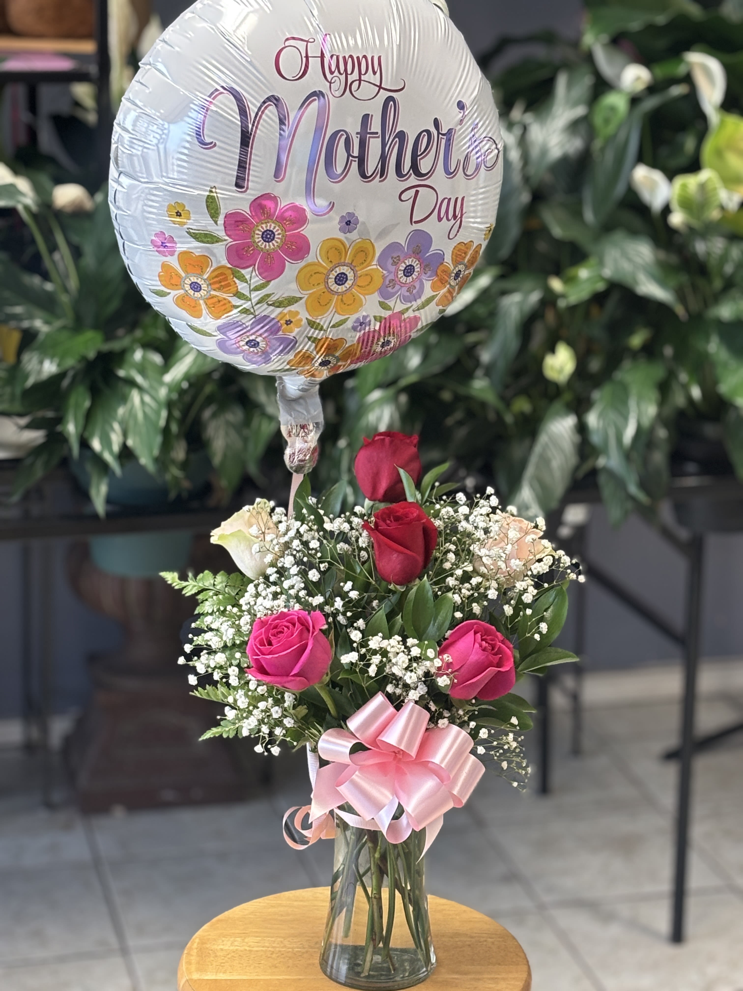 Mothers Day Rose Delight (HMD Mylar Balloon) - A sweet and elegant arrangement featuring 6 fresh roses accented with delicate baby’s breath and lush greenery, beautifully designed in a glass vase and topped with a festive Mother’s Day balloon. A perfect gift to make her feel loved and appreciated. Balloon style and vase may vary based on availability. 