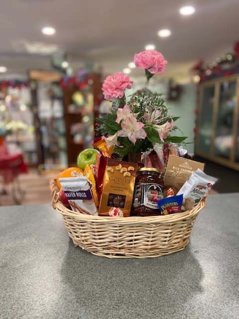 Gift basket with pink flowers and assorted snacks