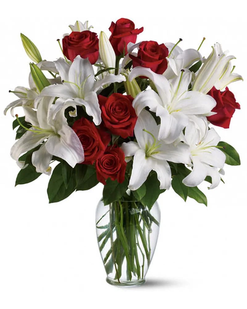 Red roses and white lilies in a clear glass vase