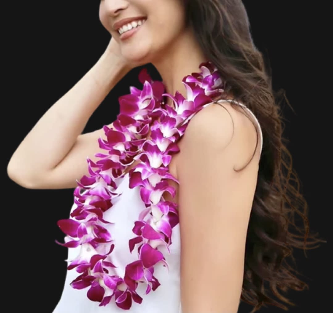Woman wearing a purple orchid lei over a white dress