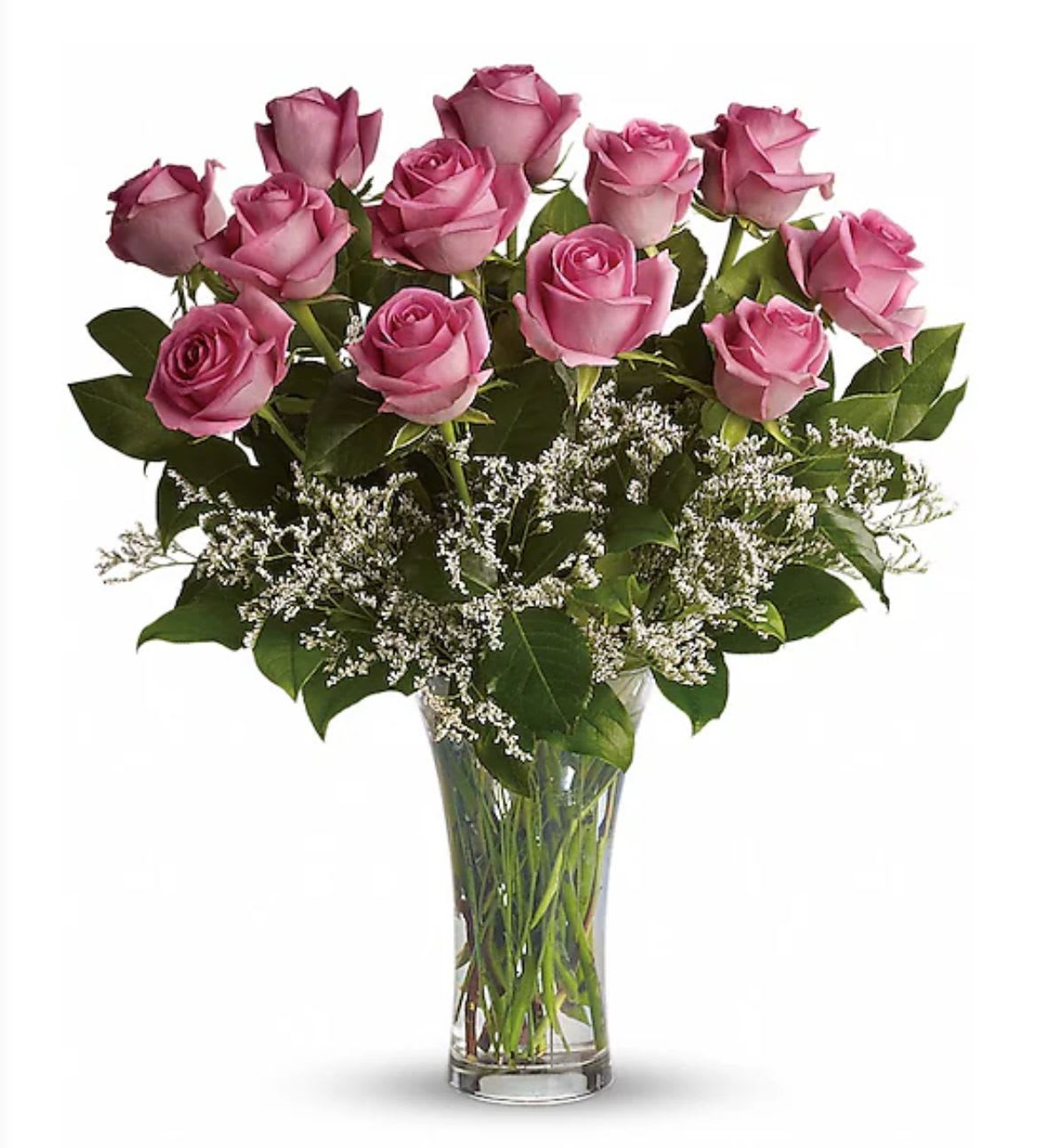Tall clear vase of pink roses with white filler flowers