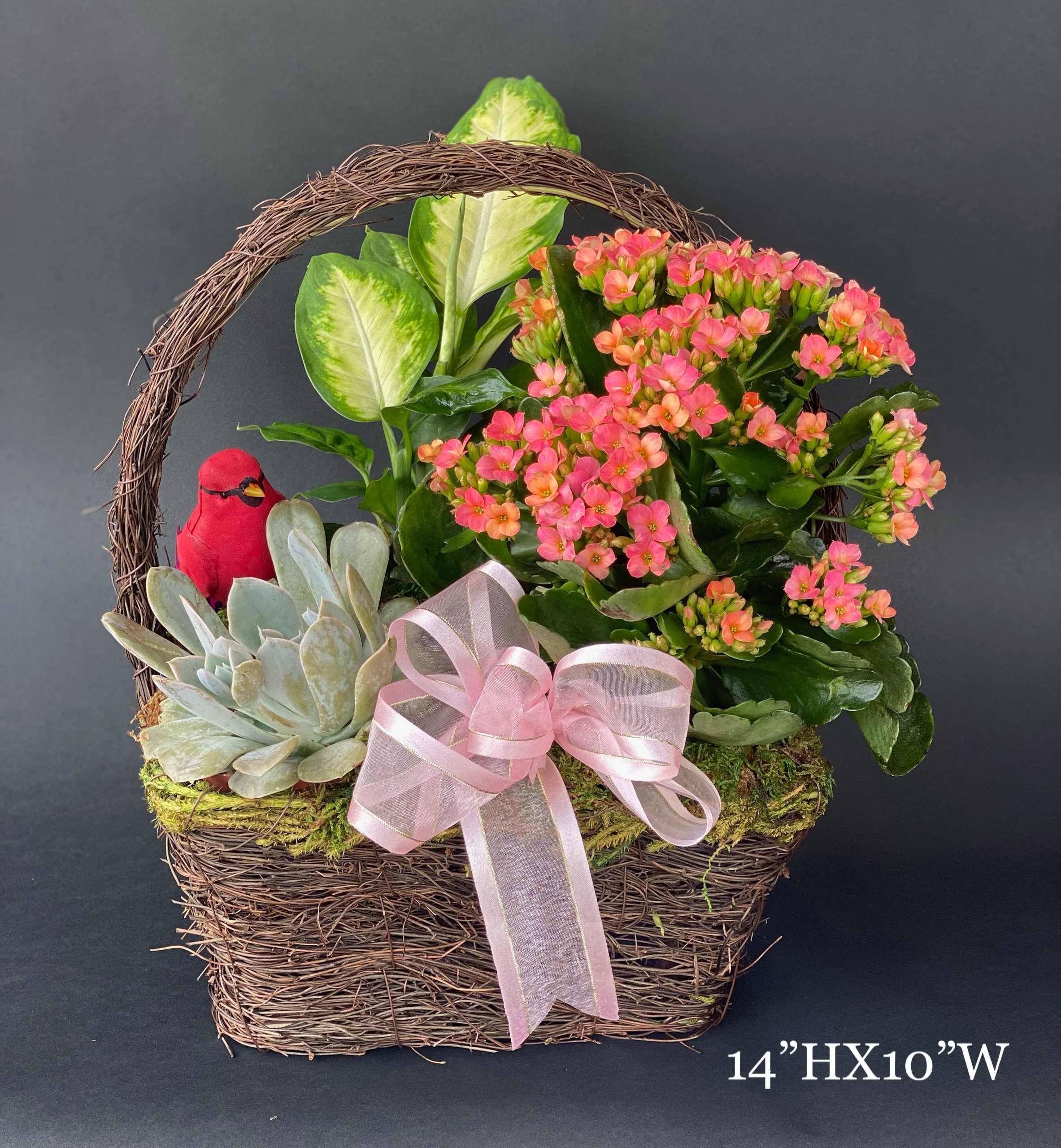 Basket arrangement with pink flowers, succulents, and a pink ribbon bow