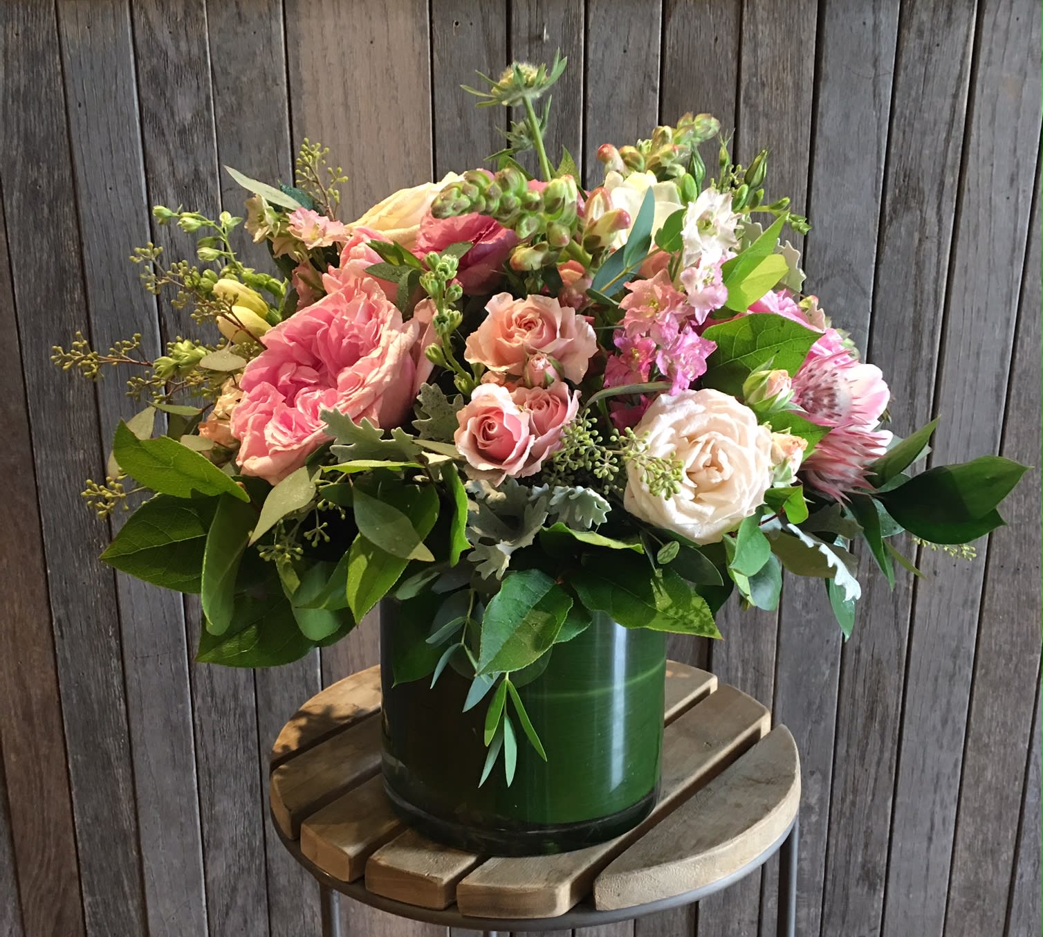 Pink and cream rose bouquet in a green vase