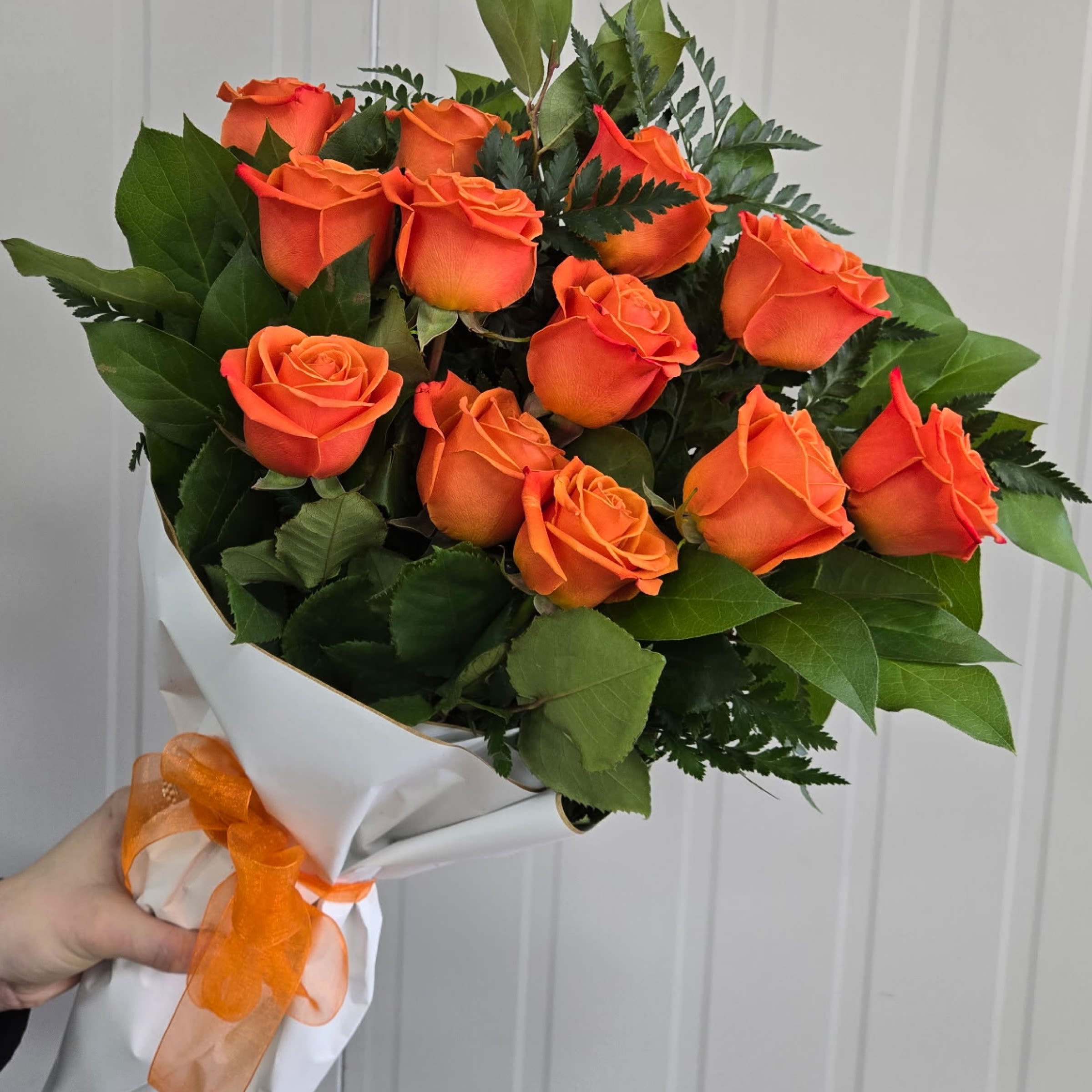 Wrap- Orange Dozen Roses - This Item includes Rose's and Greenery, Wrapped in Paper and a Matching Bow. Vase Not Included