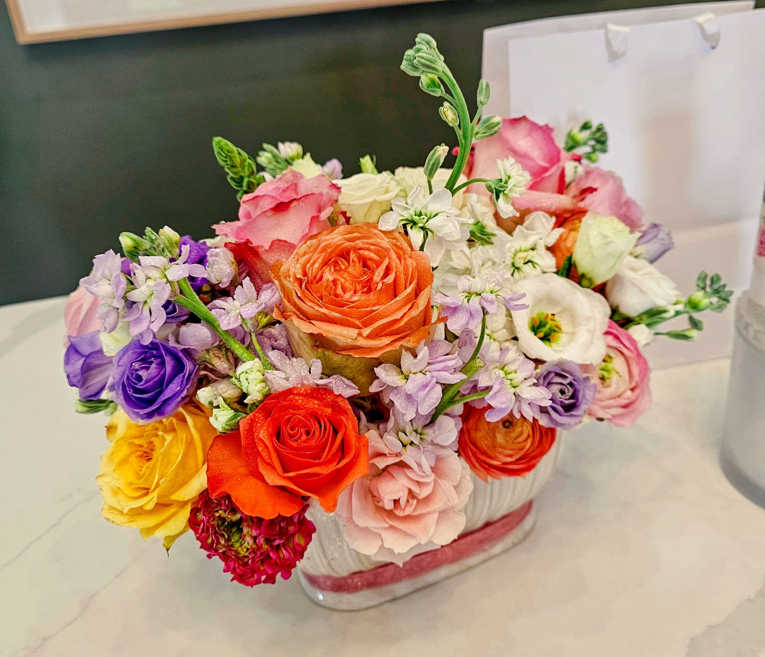Colorful mixed flower arrangement in a clear glass vase