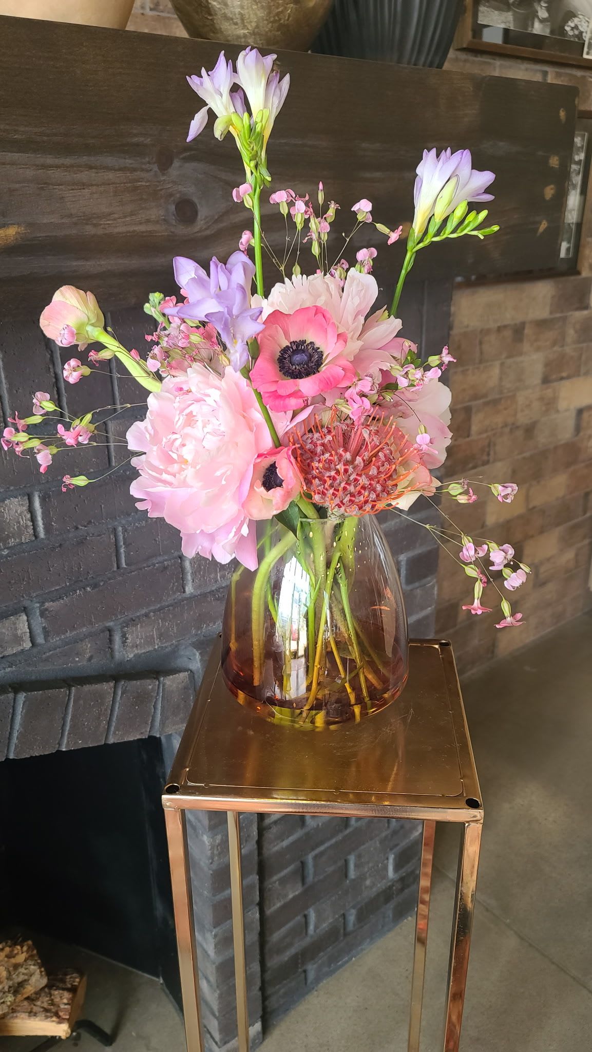 Pink and lavender flowers arranged in an amber glass vase