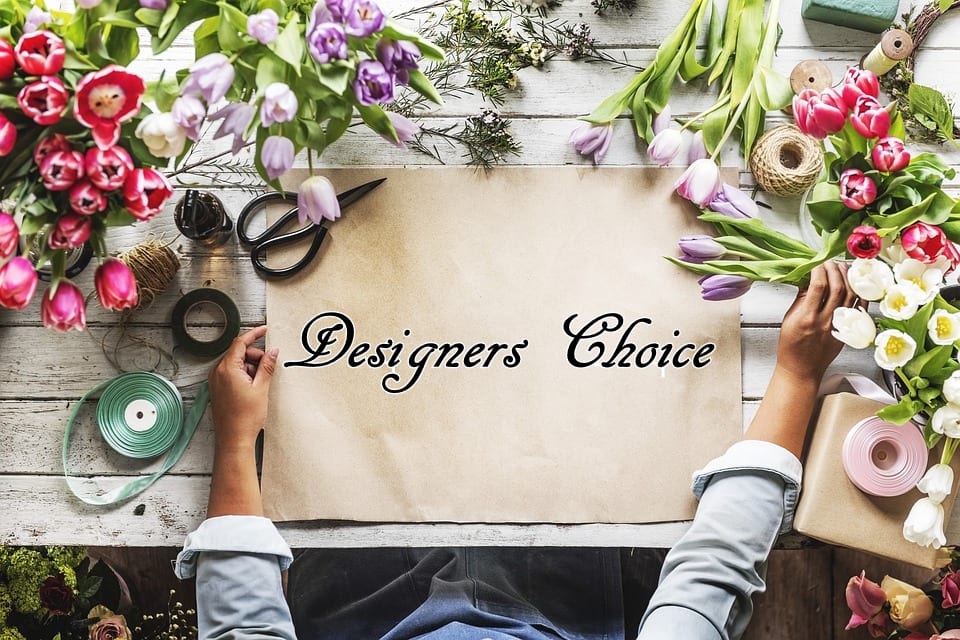 Flat lay of tulips and floral supplies around a paper sign