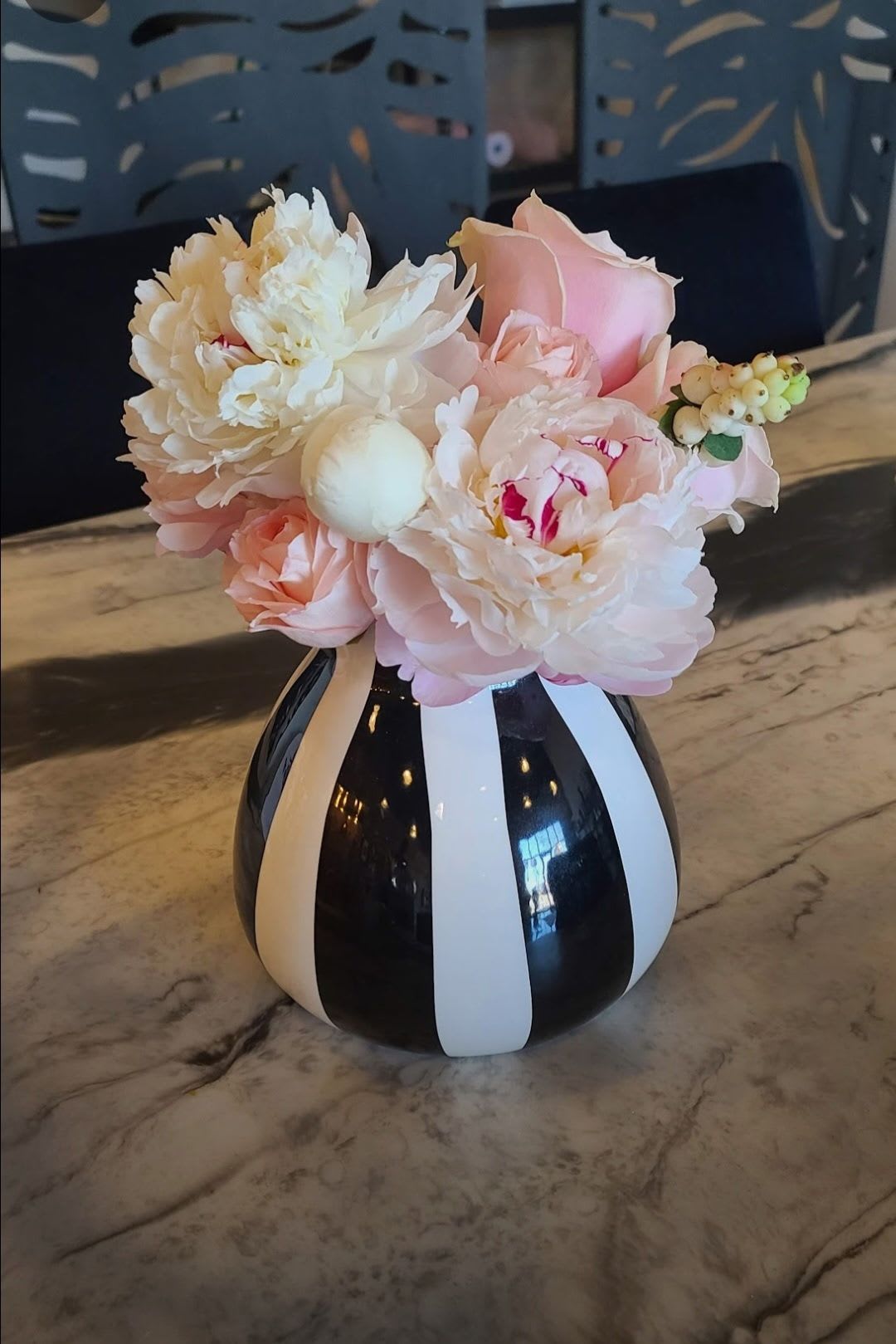 Blush Hour - When the moment calls for a little luxury, "Blush Hour" delivers. A dreamy palette of ruffled peonies, soft blush roses, and delicate berry accents arranged in a bold black-and-white striped vase. Perfect for the modern romantic who loves a little drama with their softness.  Each vase is hand-selected and may vary slightly- our designers source unique vessels to keep every arrangement one-of-a-kind.