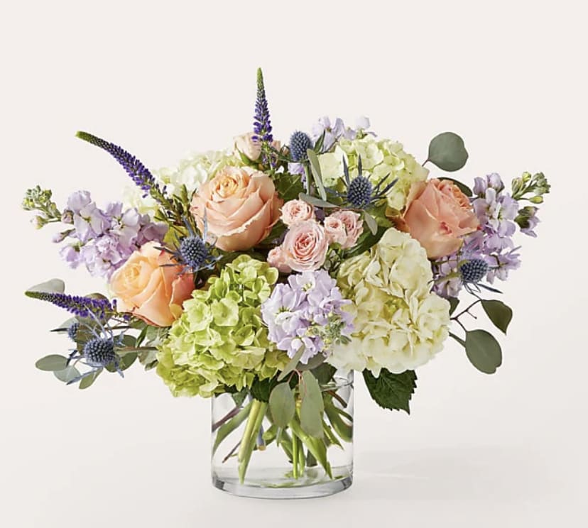 Bouquet of peach roses and hydrangeas in a clear glass vase