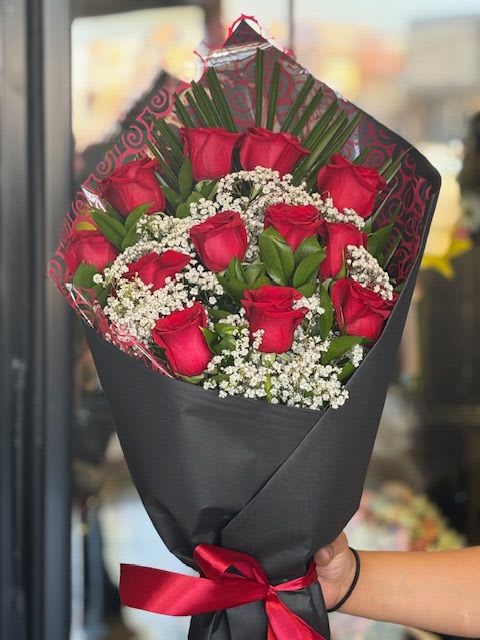 Bouquet of red roses with baby's breath wrapped in black paper