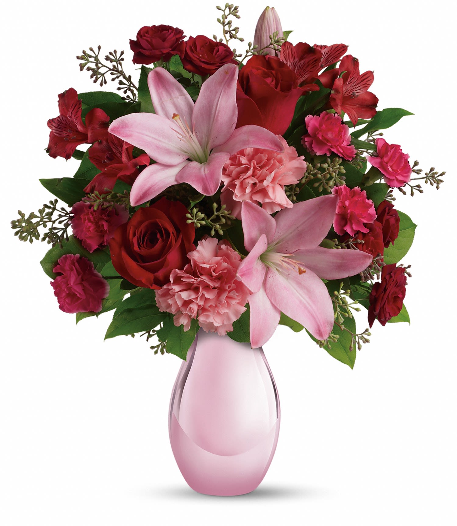 Pink lilies, red roses, and carnations in a pink glass vase