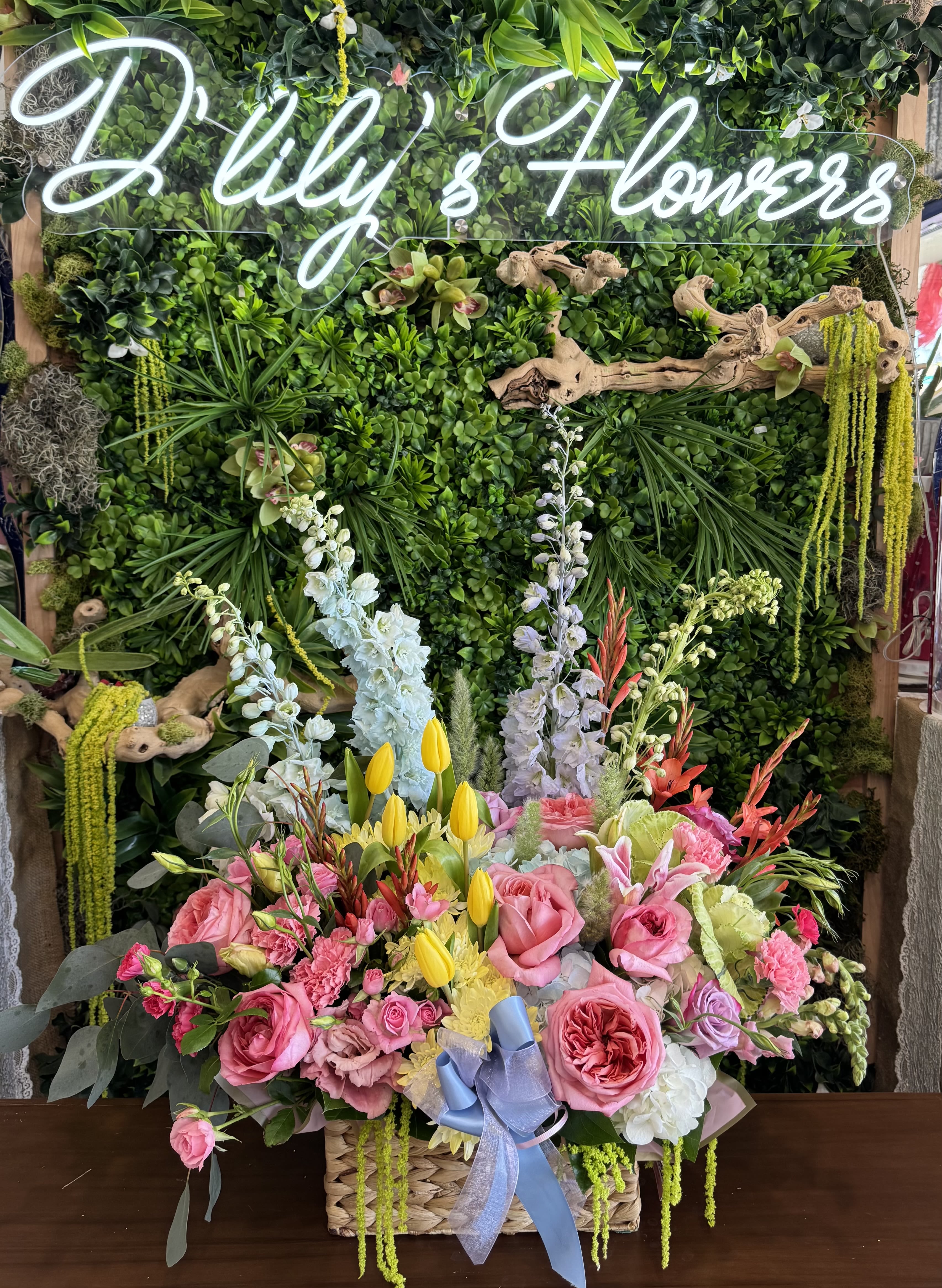 Bloom Burst Basket - A lush garden-style basket filled with soft pink roses, bright yellow tulips, and seasonal blooms, beautifully arranged with fresh greenery for a cheerful, elegant touch. Disclaimer: Flowers may be substituted based on availability while maintaining the overall look and feel.