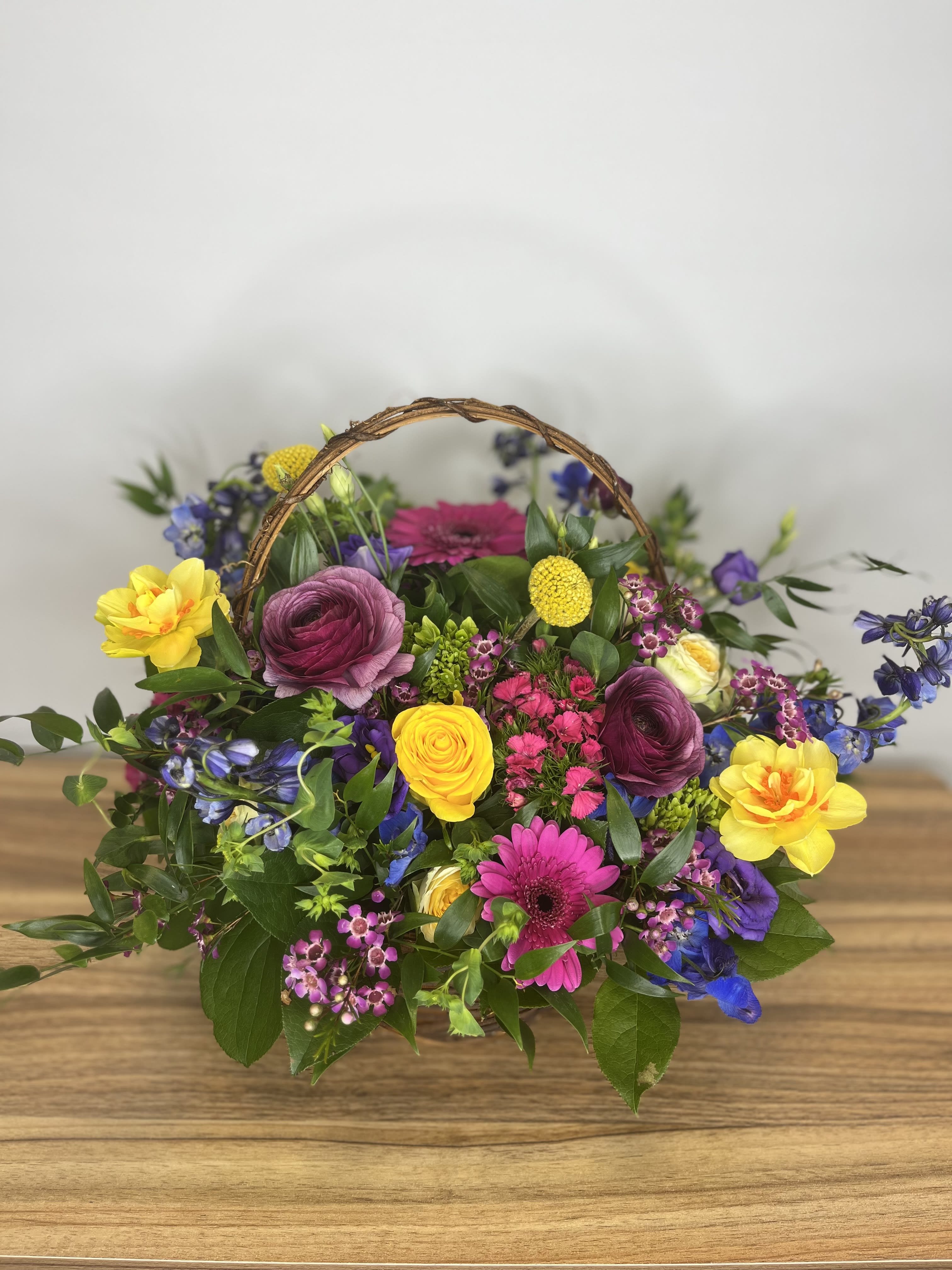 Colorful mixed flower basket with a woven handle