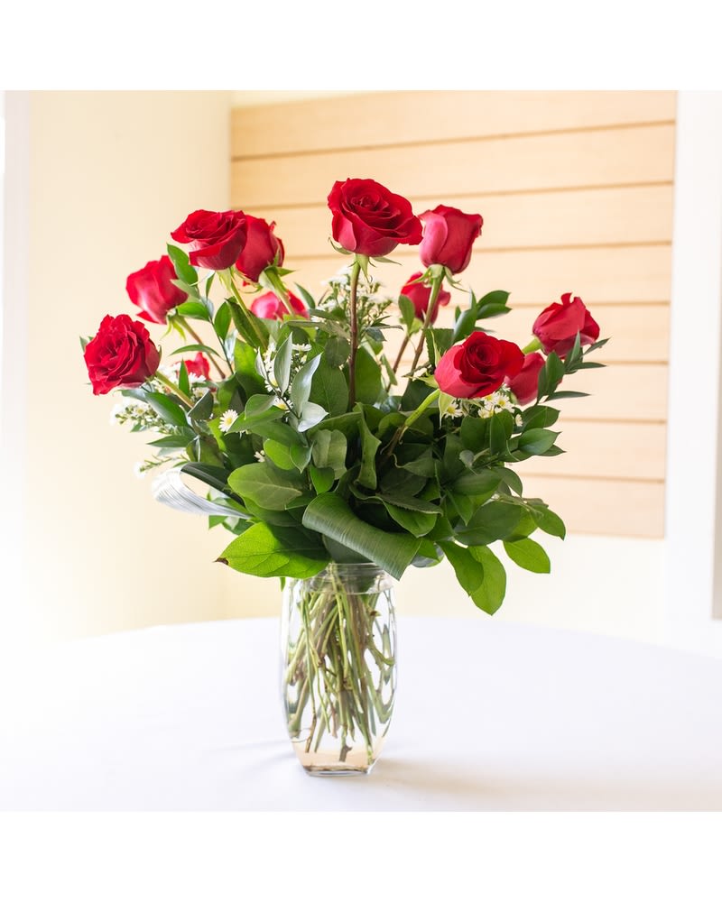 Red roses arranged in a clear glass vase