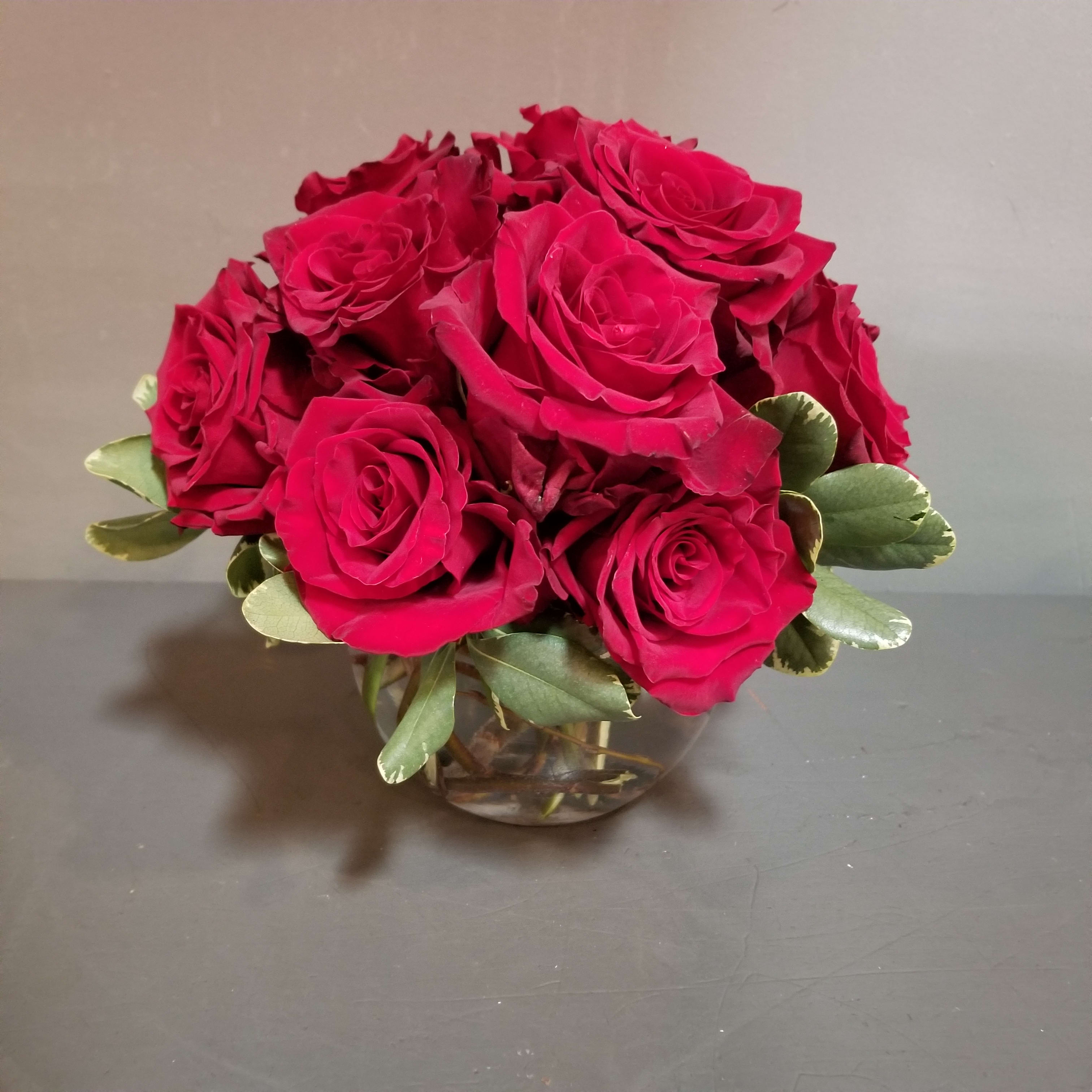 Red Rose Centerpiece - A sophisticated bouquet - a clear bowl filled with 12 fresh red roses, designed low for high-impact.  Measures approx. 10x10" 