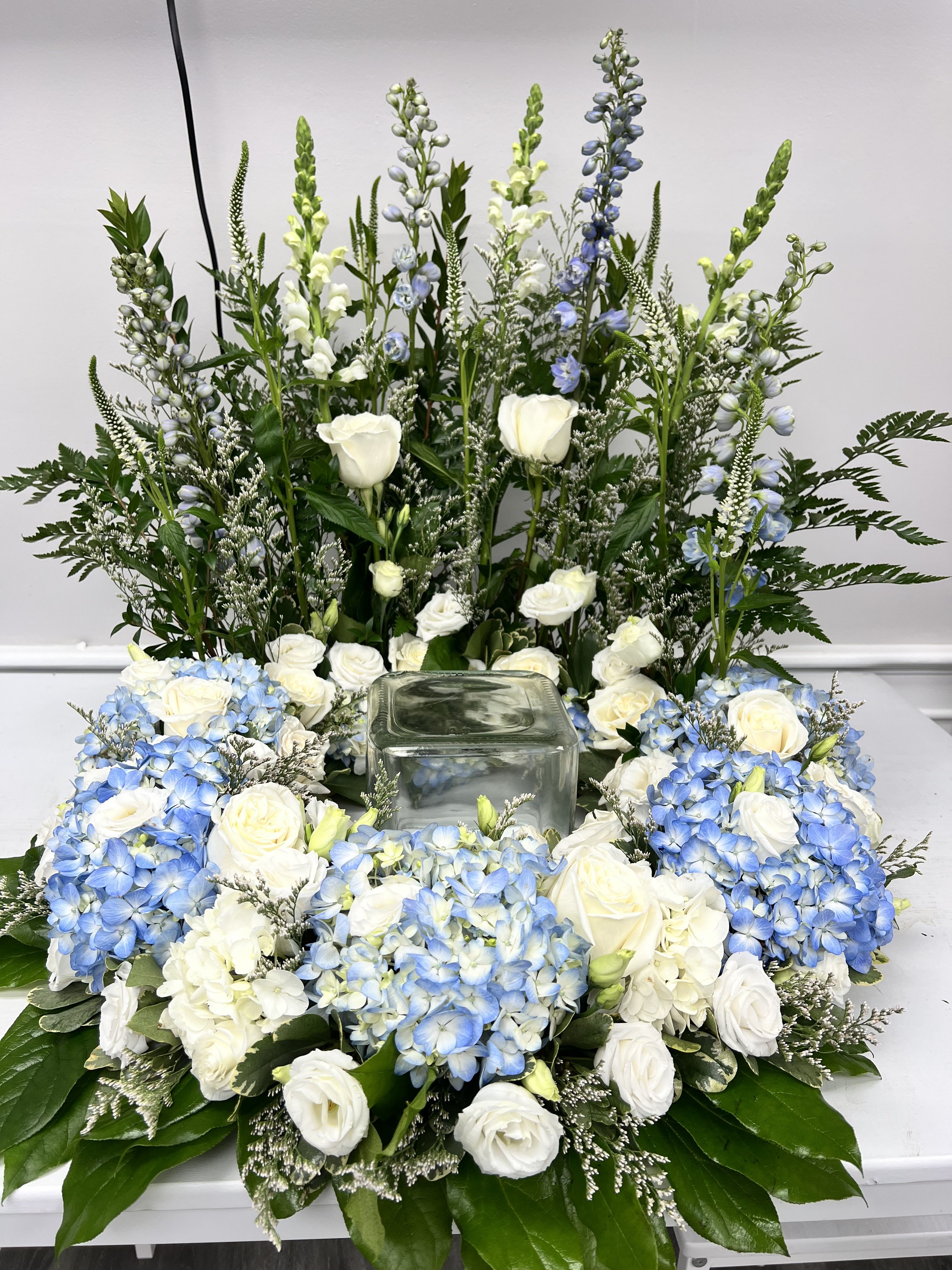 Sympathy: Urn Arrangement $199 &amp; up - This arrangement surrounds the urn of your loved one with beautiful seasonal flowers. Pictured Arrangement is Deluxe Price. Containers and flowers may vary from pictured arrangement.