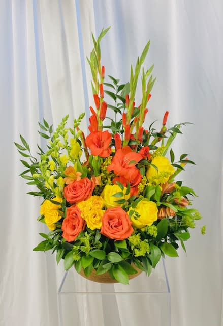 Orange Explosion - A beautiful modern display of orange and yellow flowers.  Flowers included in the design are roses, spray roses, gladiola, snapdragon, alstroemeria, and greenery.  Design set in a neutral color vase.