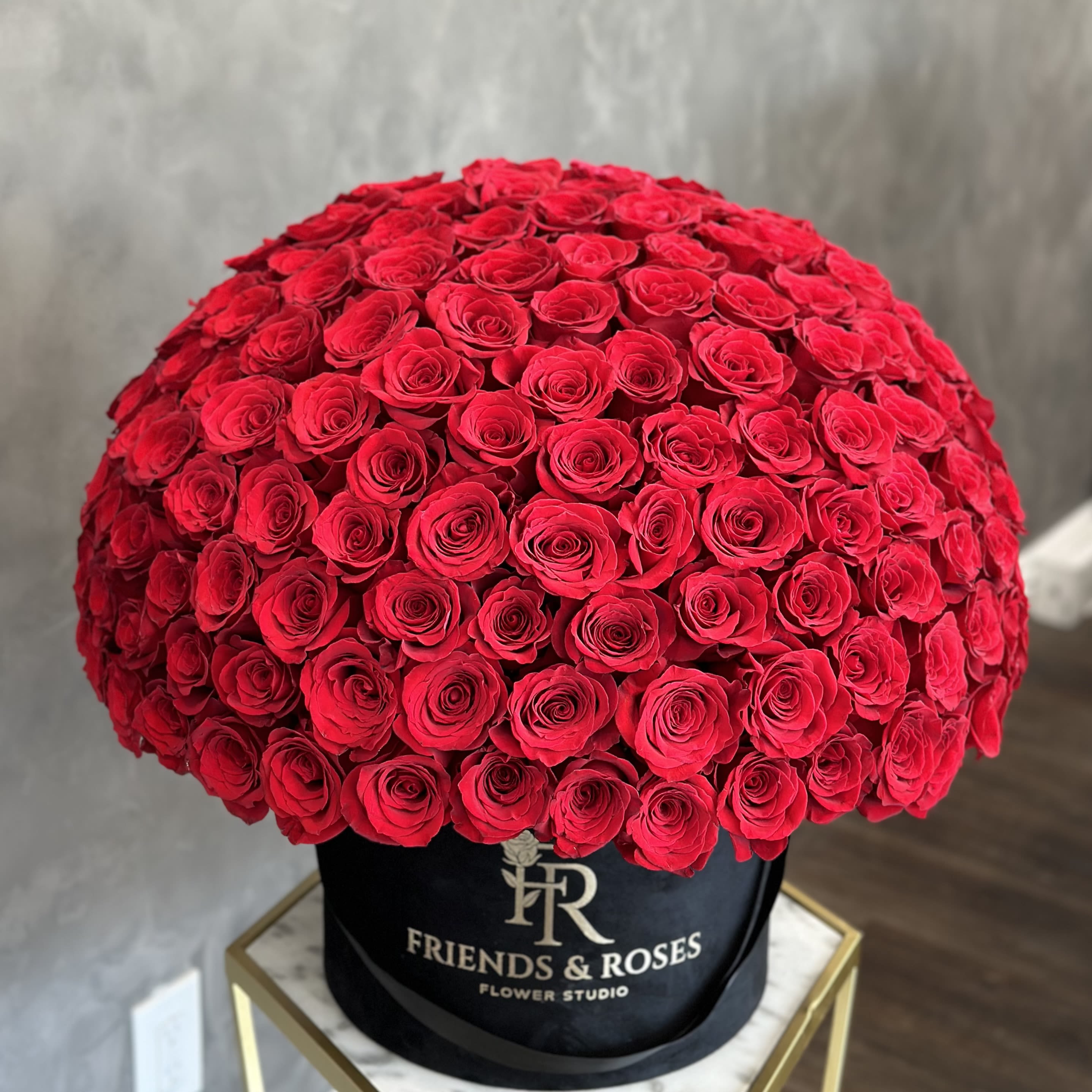 Large dome of red roses in a black hatbox