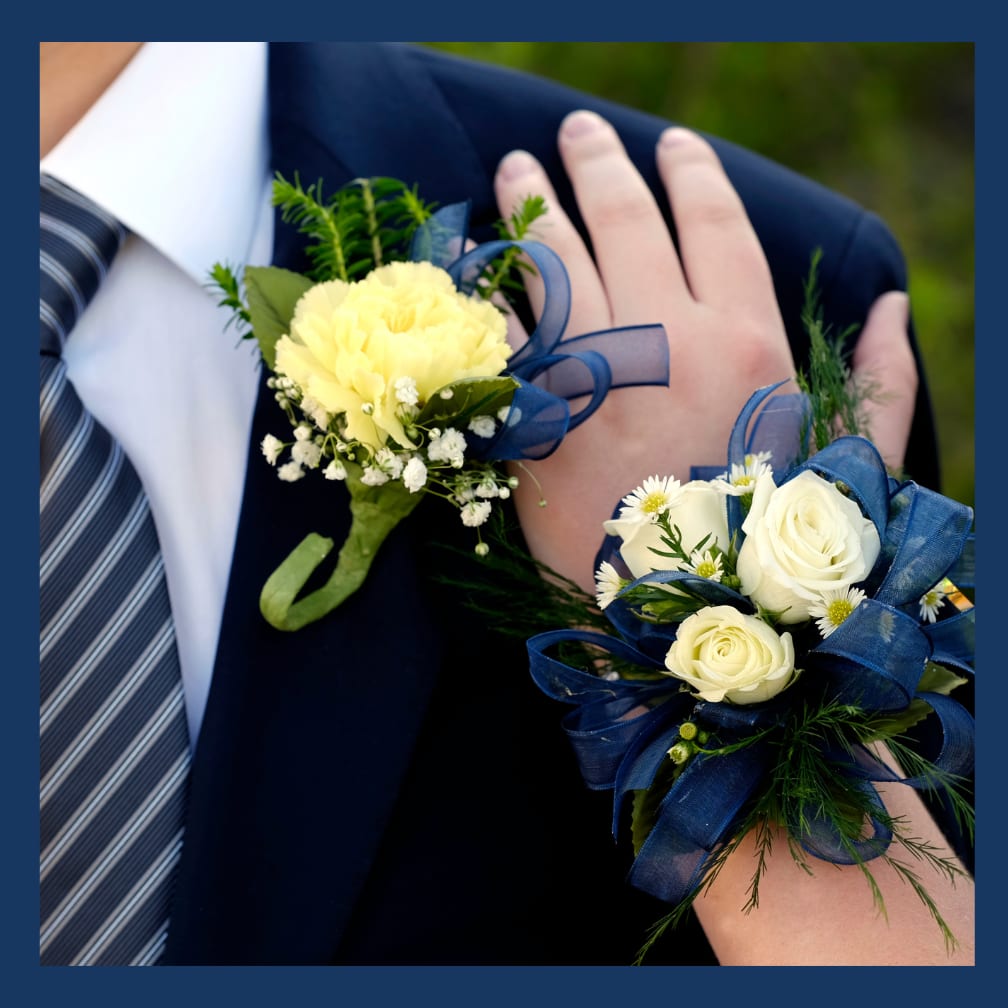 Yellow carnation boutonniere and white rose wrist corsage with blue ribbon on a suit.