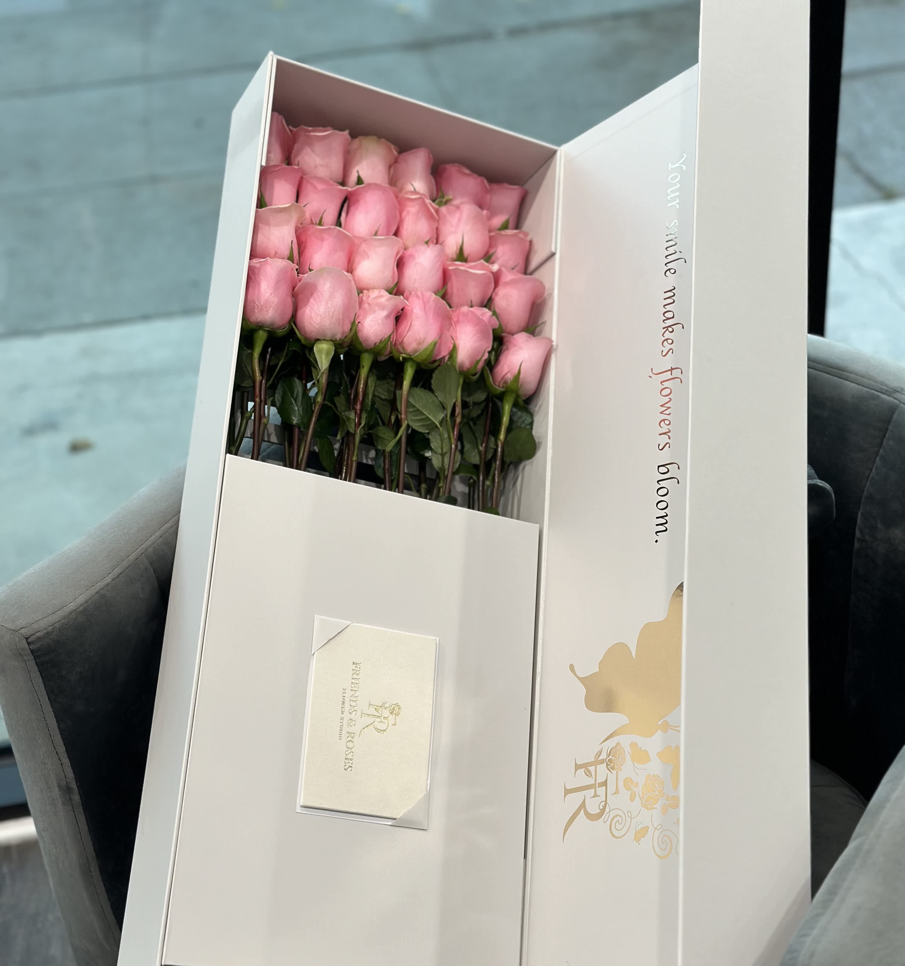 Boxed bouquet of pink roses with a card inside