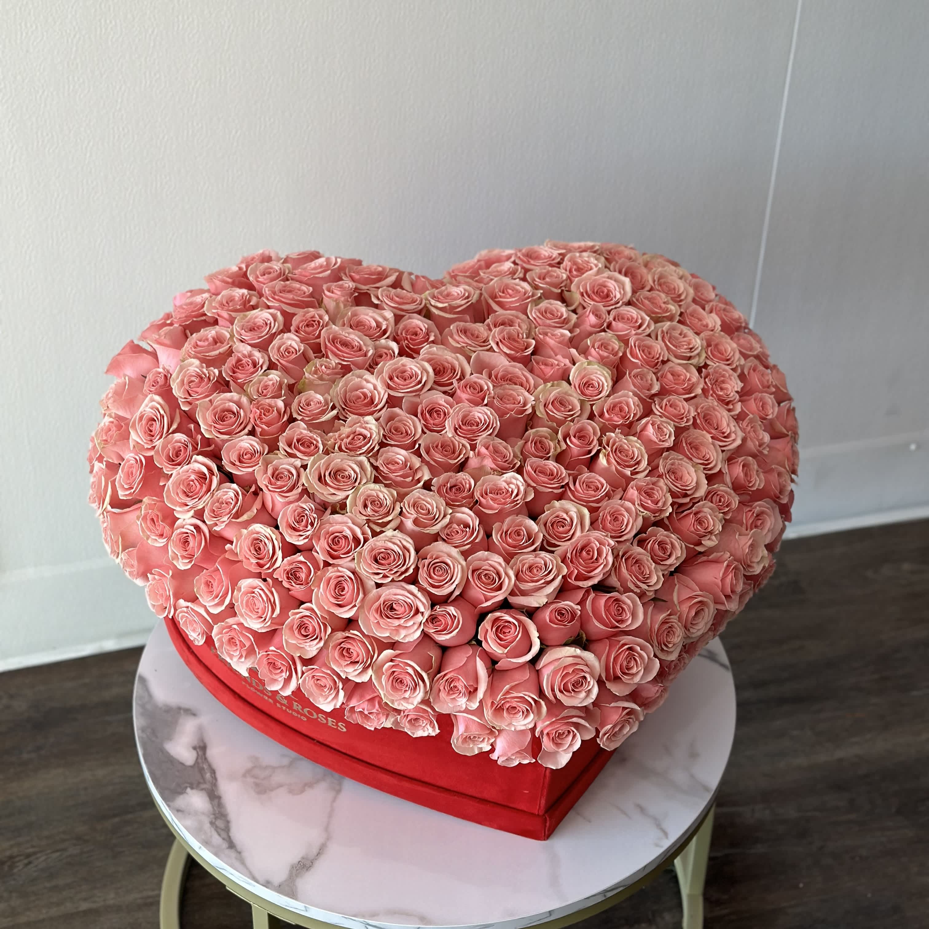 Heart-shaped box filled with pink roses