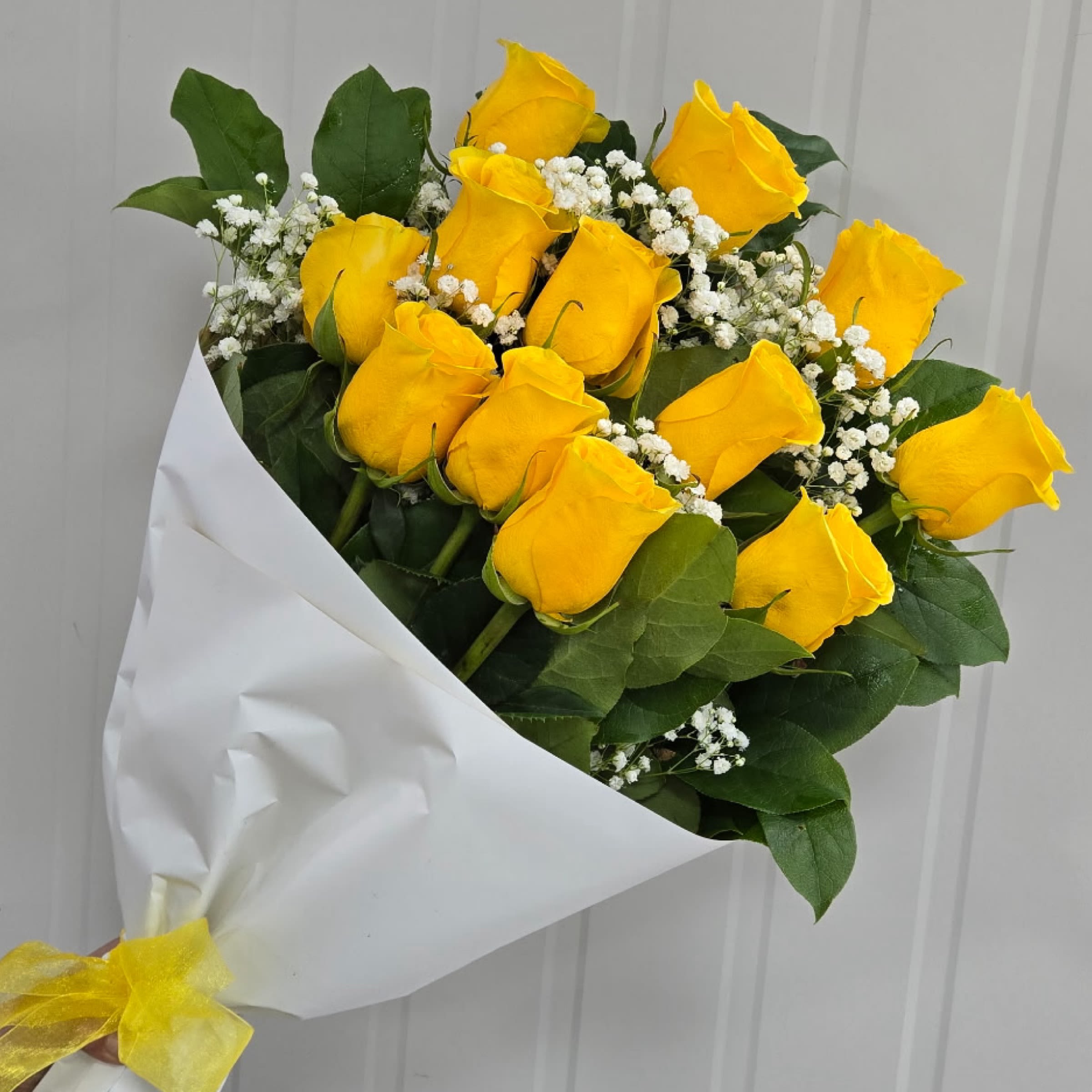 Wrap- Classic Yellow Dozen Roses - This Item includes Rose's, Filler Flower and Greenery Wrapped in Paper and a Matching Bow. Vase Not Included